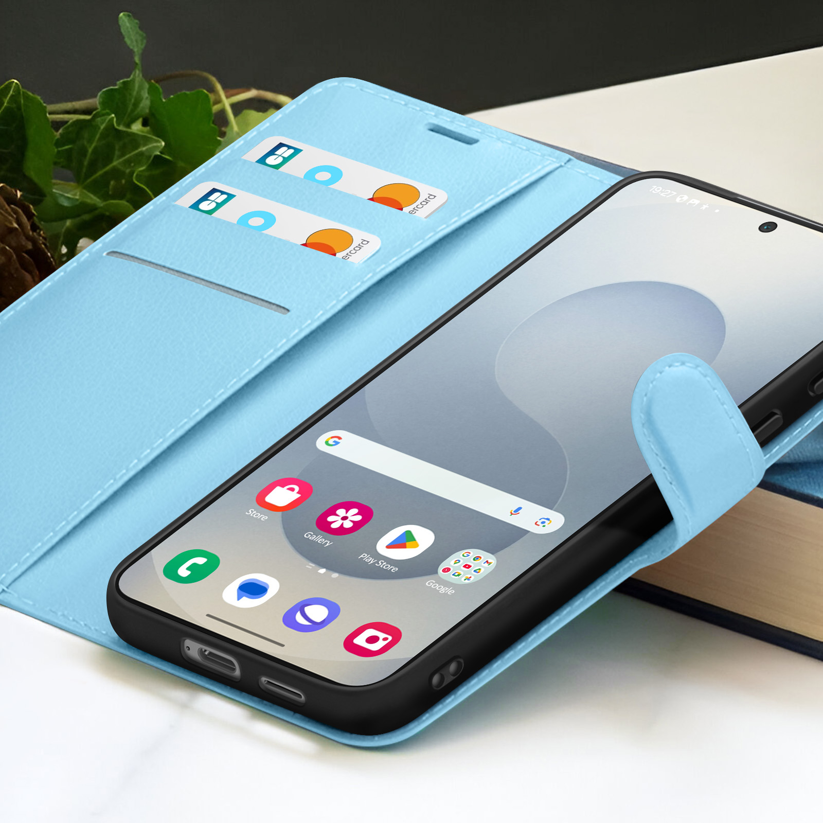 Een smartphone in een lichtblauwe portemonnee. Creditcards zitten in de kaartsleuven. De telefoon toont pictogrammen.