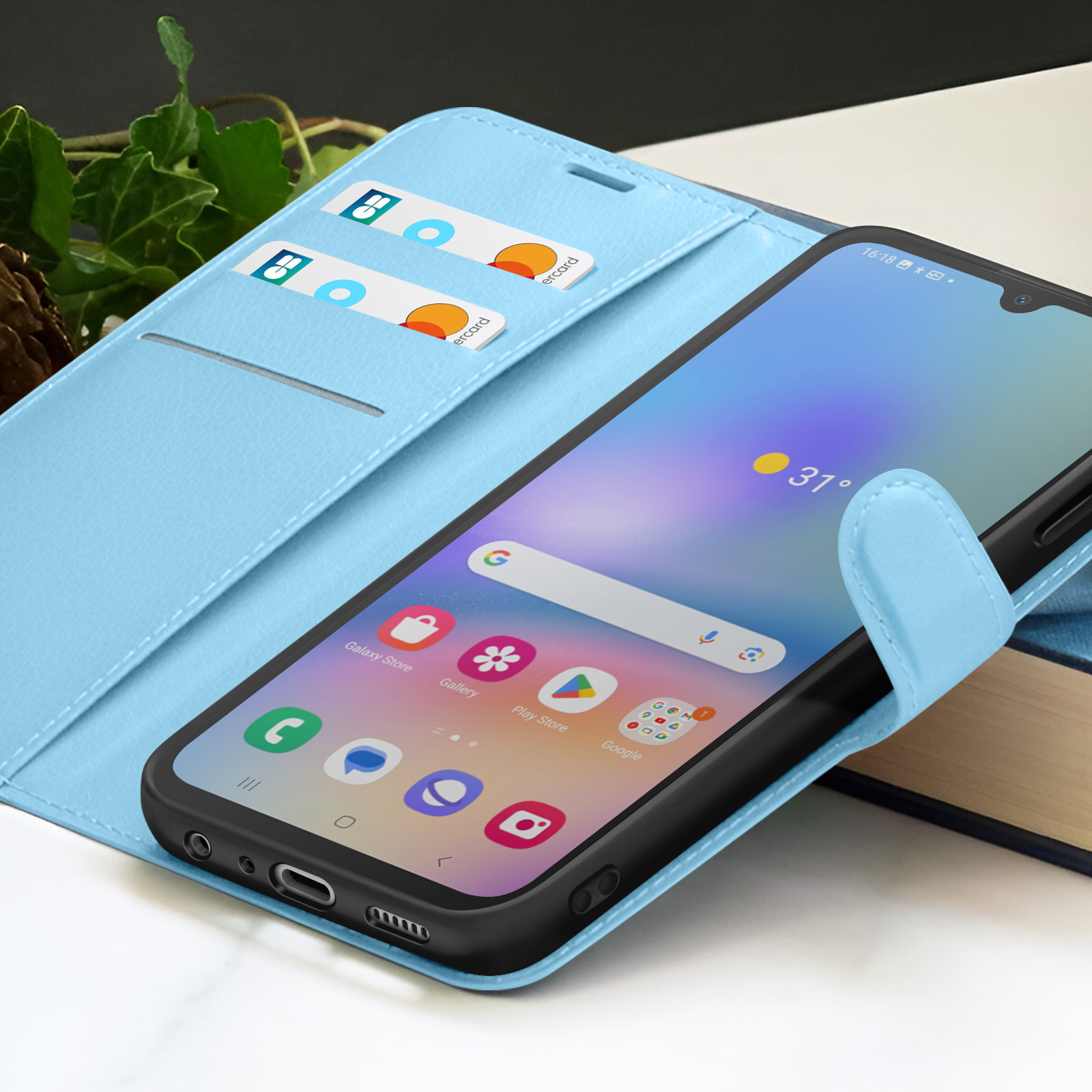 Un smartphone dans un étui bleu clair. L'écran affiche des icônes d'applications. Deux cartes de crédit dans l'étui.
