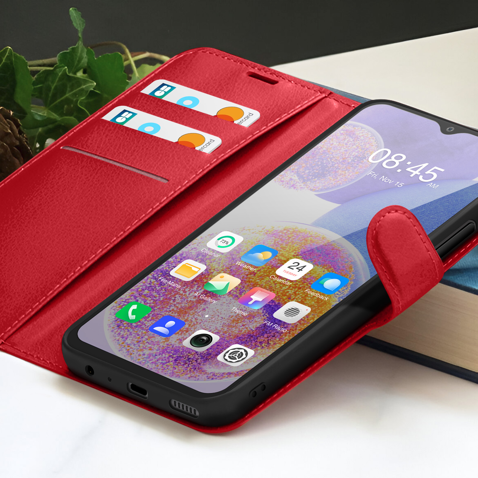 Una custodia rossa con uno smartphone che mostra l'ora. Carte di credito visibili. App e icone sullo schermo.