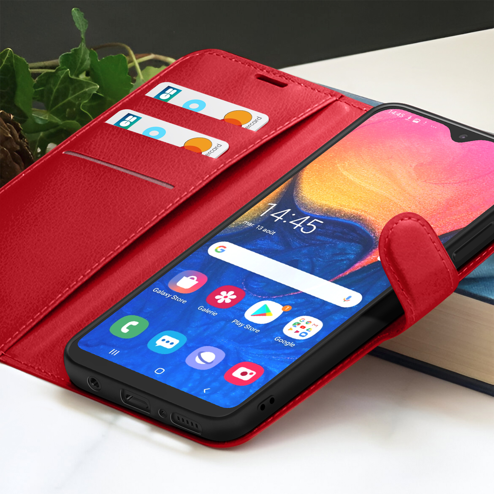 Een rode telefoonhoes met een smartphone erin. De telefoon toont tijd en apps. Creditcards in de hoes.