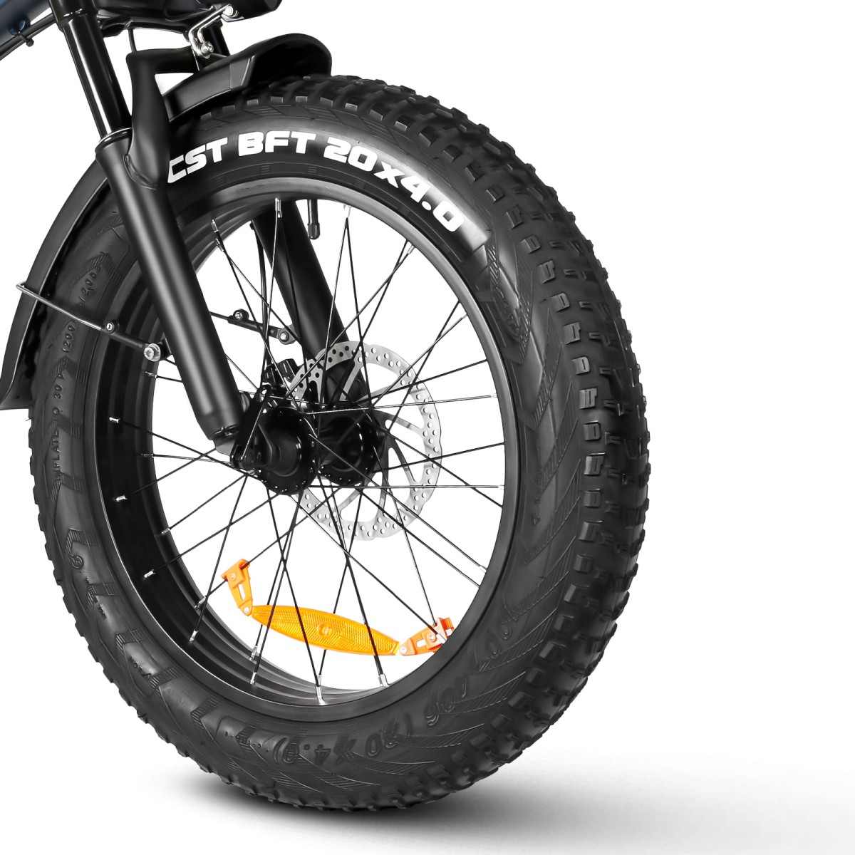Zbliżenie czarnego koła rowerowego z grubą oponą. Opona ma biały tekst 'CST BFT 20X4.0'. Dołączony jest pomarańczowy odblask.