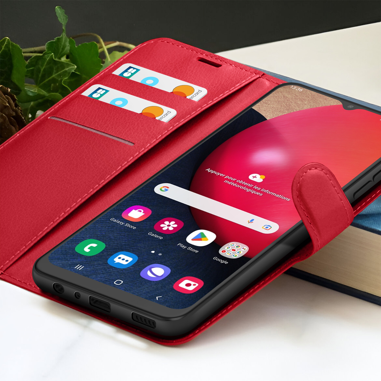 Een rode telefoonhoes met een telefoon die een startscherm met app-iconen weergeeft. Er zitten creditcards in de hoes.