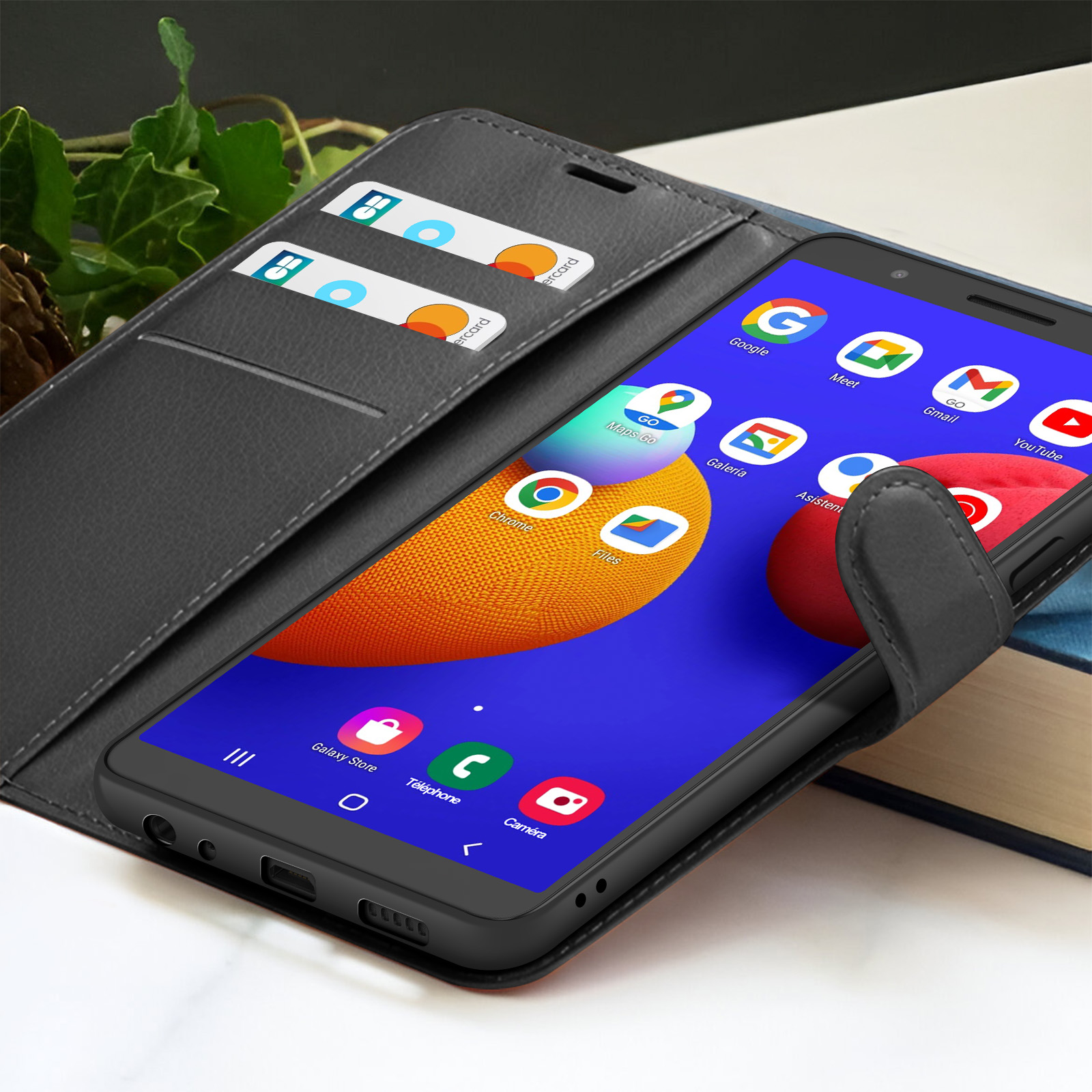 Smartphone in custodia nera con carte di credito. Lo schermo mostra app. La custodia è aperta su un tavolo.