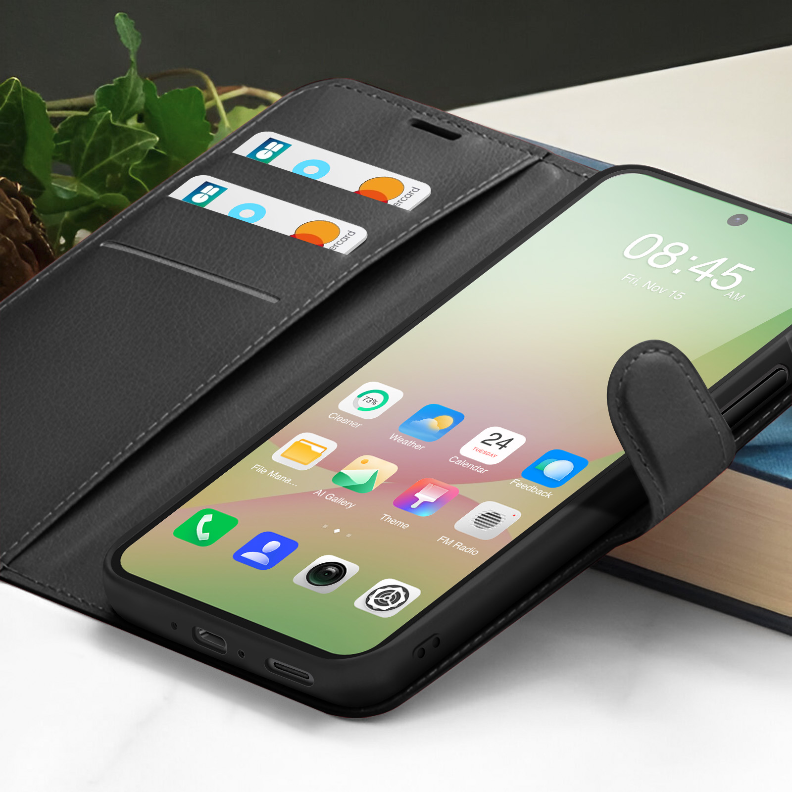 Een smartphone toont apps. De telefoon zit in een zwarte hoes, in een wallet case met kaartsleuven. De tijd is 08:45.