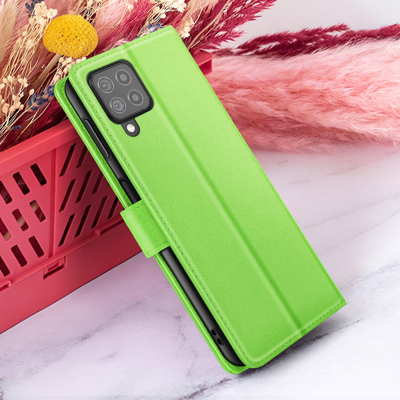 Groene telefoonhoes met camera, open. Roze en rode bloemen op de achtergrond. Rode mand.