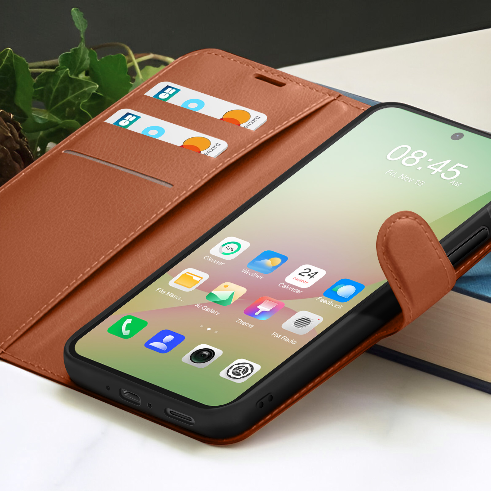 Un smartphone affiche l'heure et des applications, à l'intérieur d'un étui en cuir marron. Deux cartes de crédit sont visibles.
