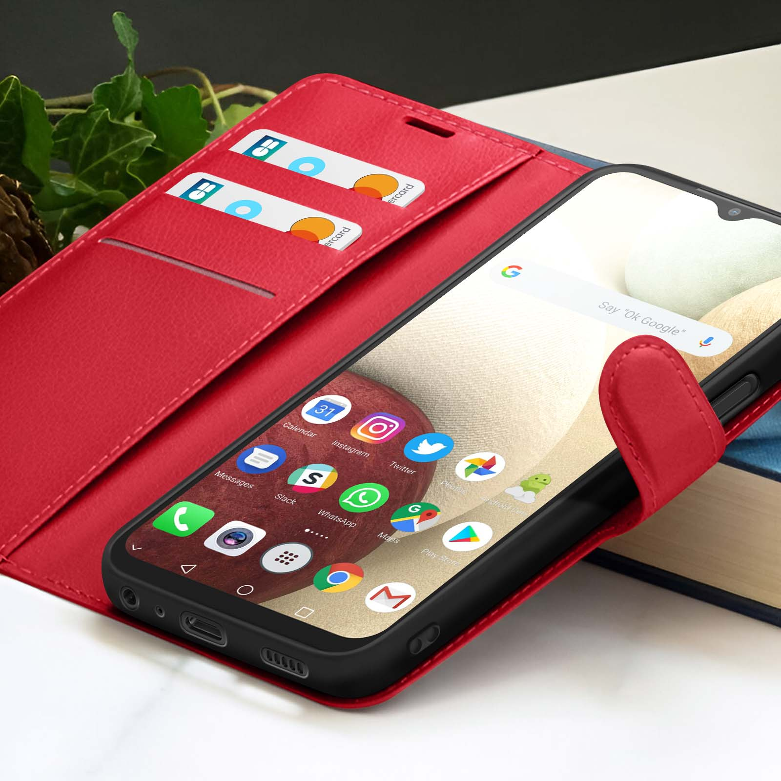 Un étui de téléphone rouge avec un téléphone affichant des icônes d'applications. Deux cartes sont visibles à l'intérieur de l'étui. Un livre est en arrière-plan.