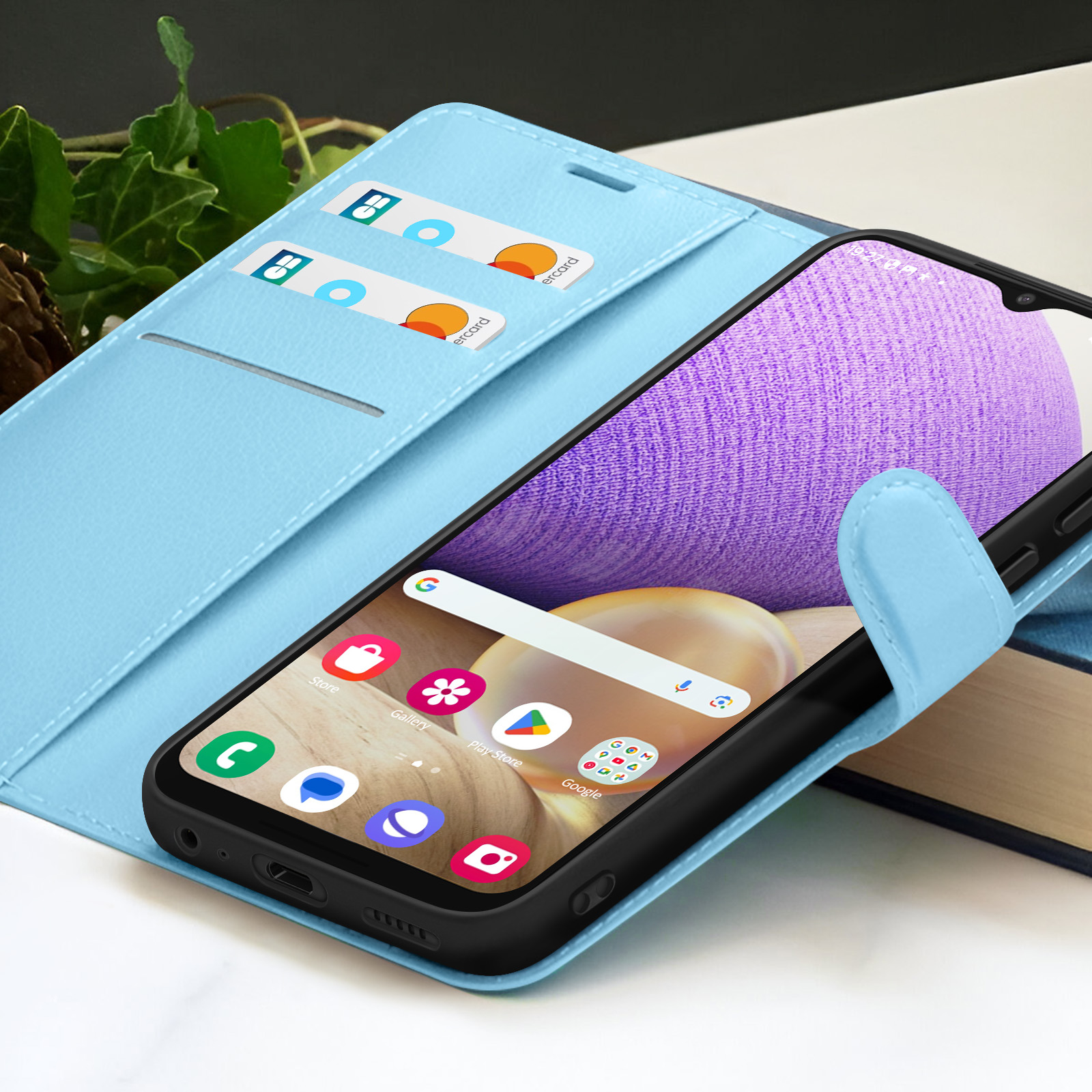 Ein Smartphone in einer hellblauen Hülle mit Kreditkarten im Cover. Der Bildschirm zeigt Apps und eine Suchleiste.