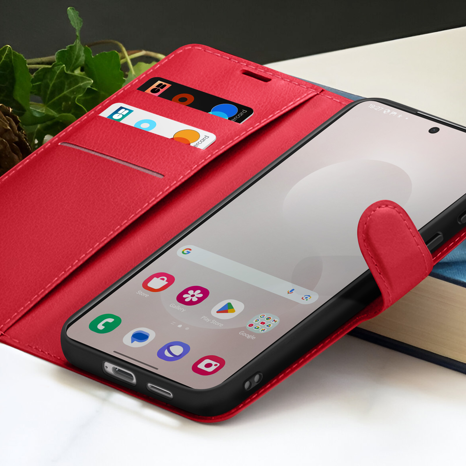 Un étui de téléphone rouge contient un smartphone avec des icônes. Cartes de crédit sont visibles.