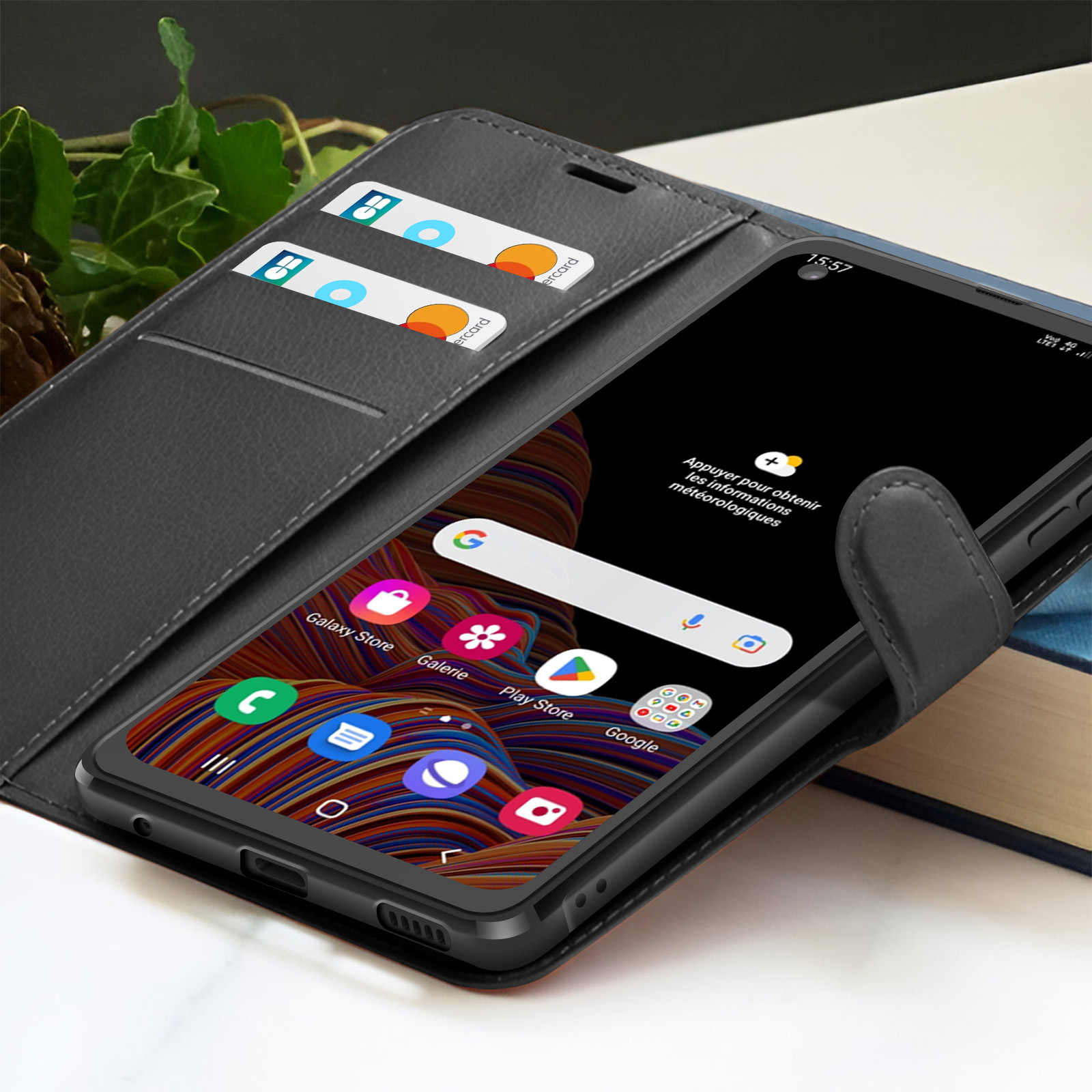 Uno smartphone in una custodia a portafoglio mostra icone. Carte di credito nel portafoglio. Sfondo scuro.