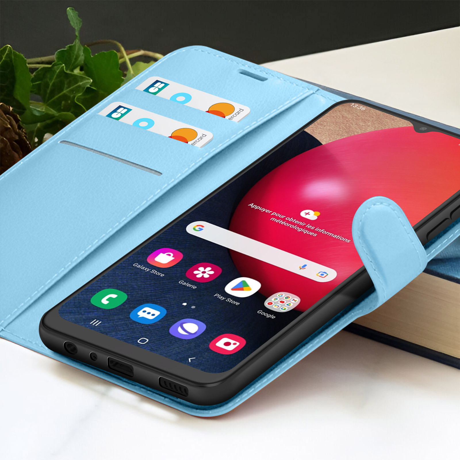 Een smartphone in een blauwe case is open, toont apps en een rood scherm. Creditcards in de sleuven.
