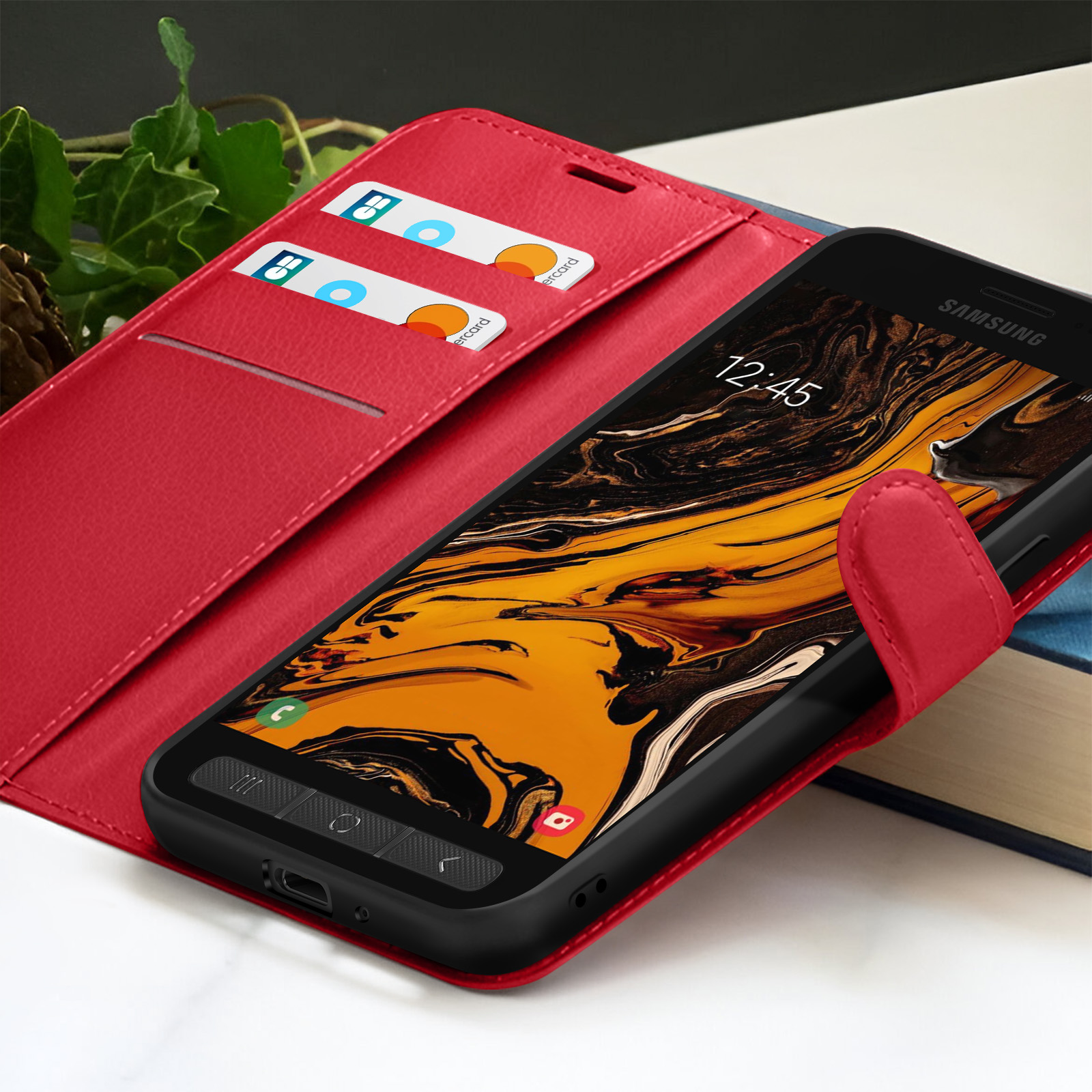 Étui de téléphone rouge avec téléphone Samsung. Cartes de crédit dans l'étui. Le téléphone affiche 12:45.