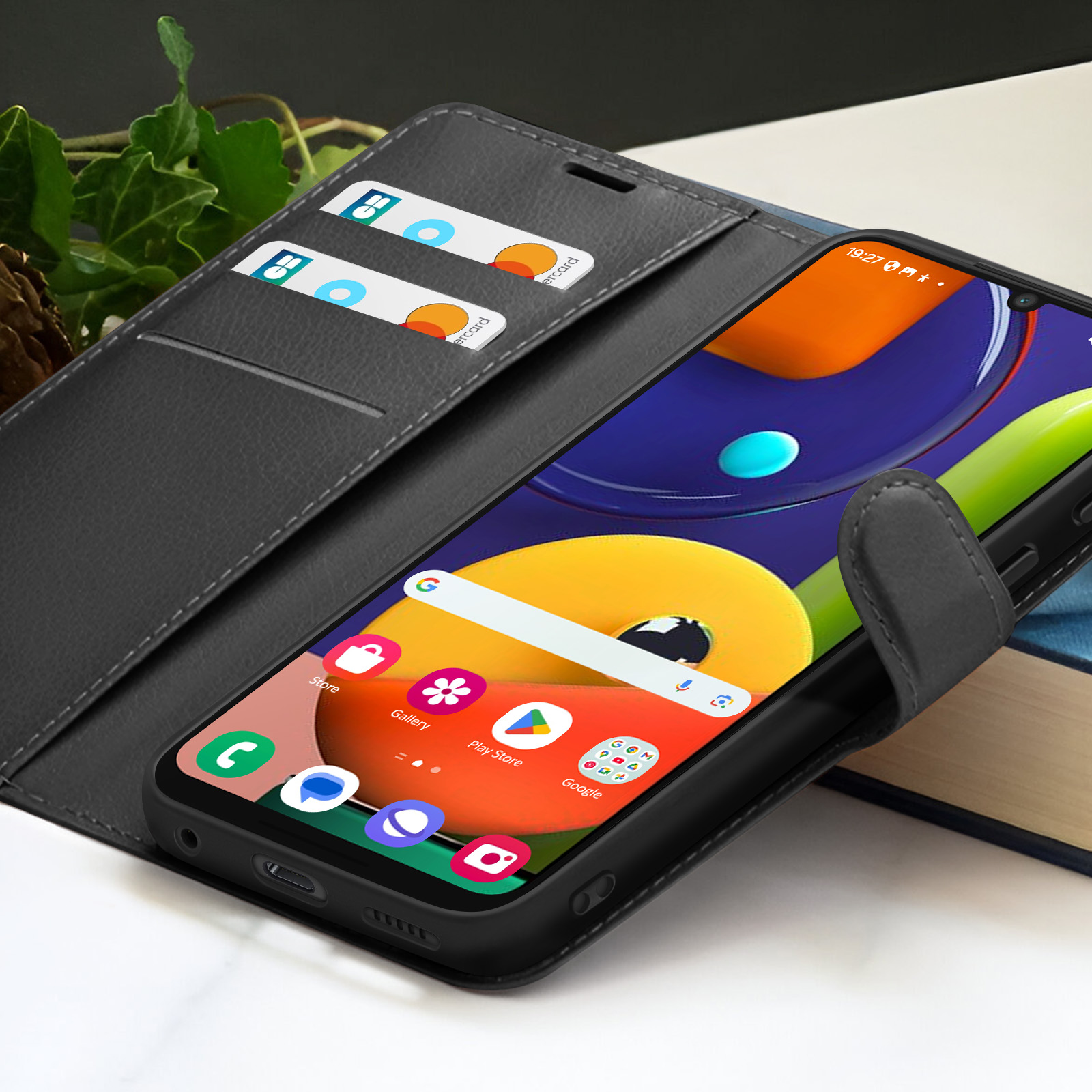 Un telefono nero in una custodia, con carte di credito nello slot della custodia. Il telefono mostra le app. Lo sfondo è sfocato.