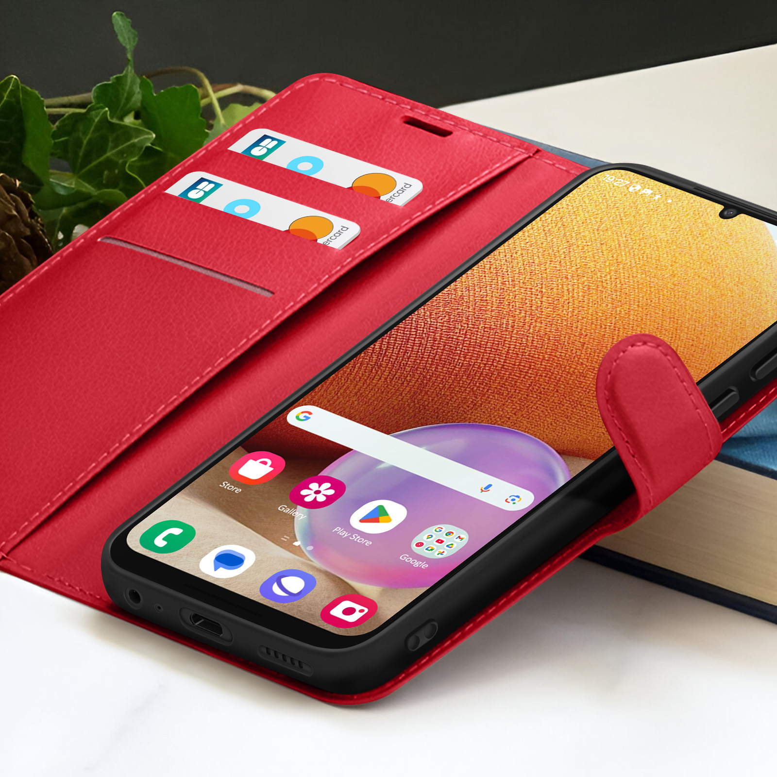 Een smartphone in een rode hoes, open om het scherm te laten zien, met creditcards in de hoes.