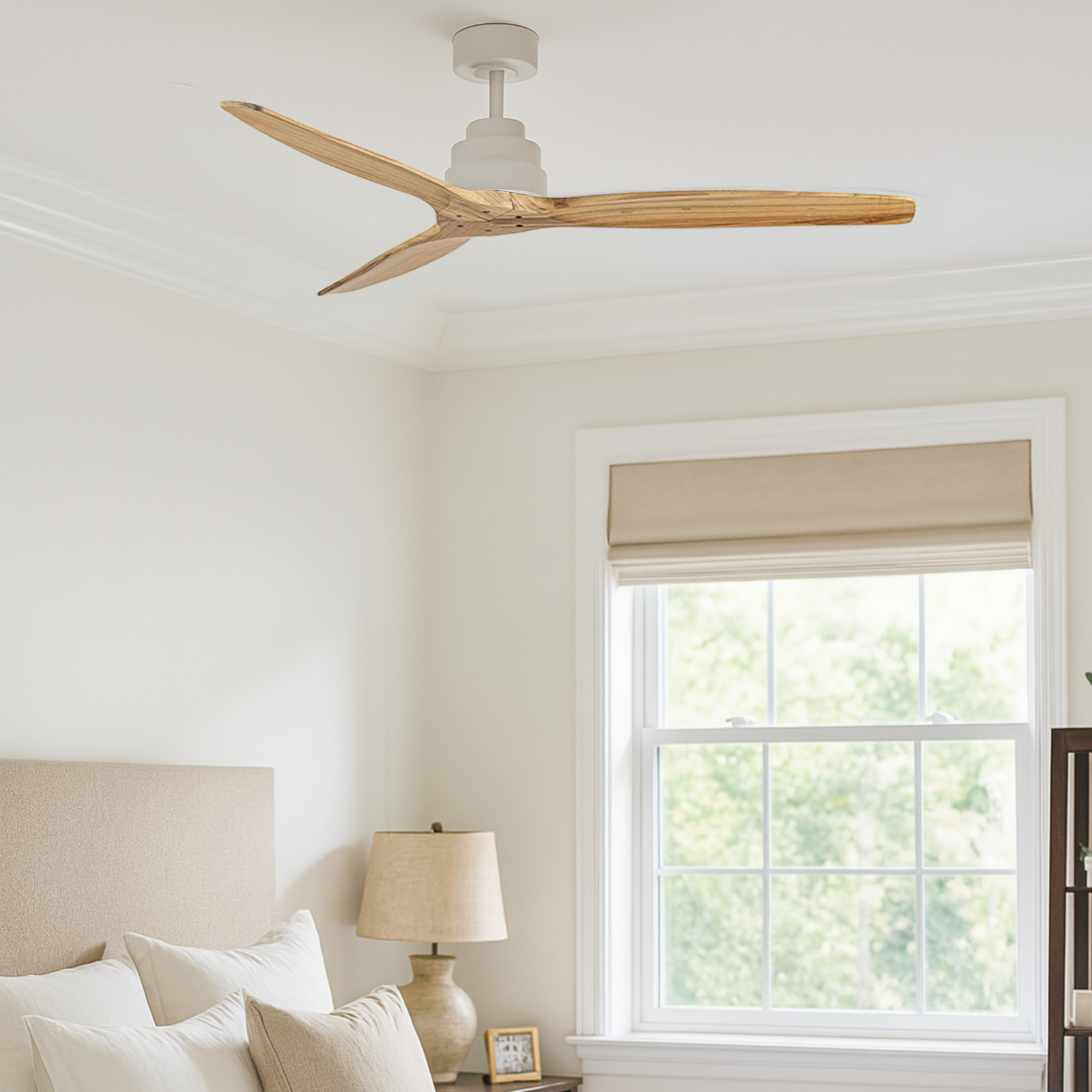 Un dormitorio con ventilador de techo, ventana y cama. El ventilador tiene aspas de madera. La ventana da a árboles.