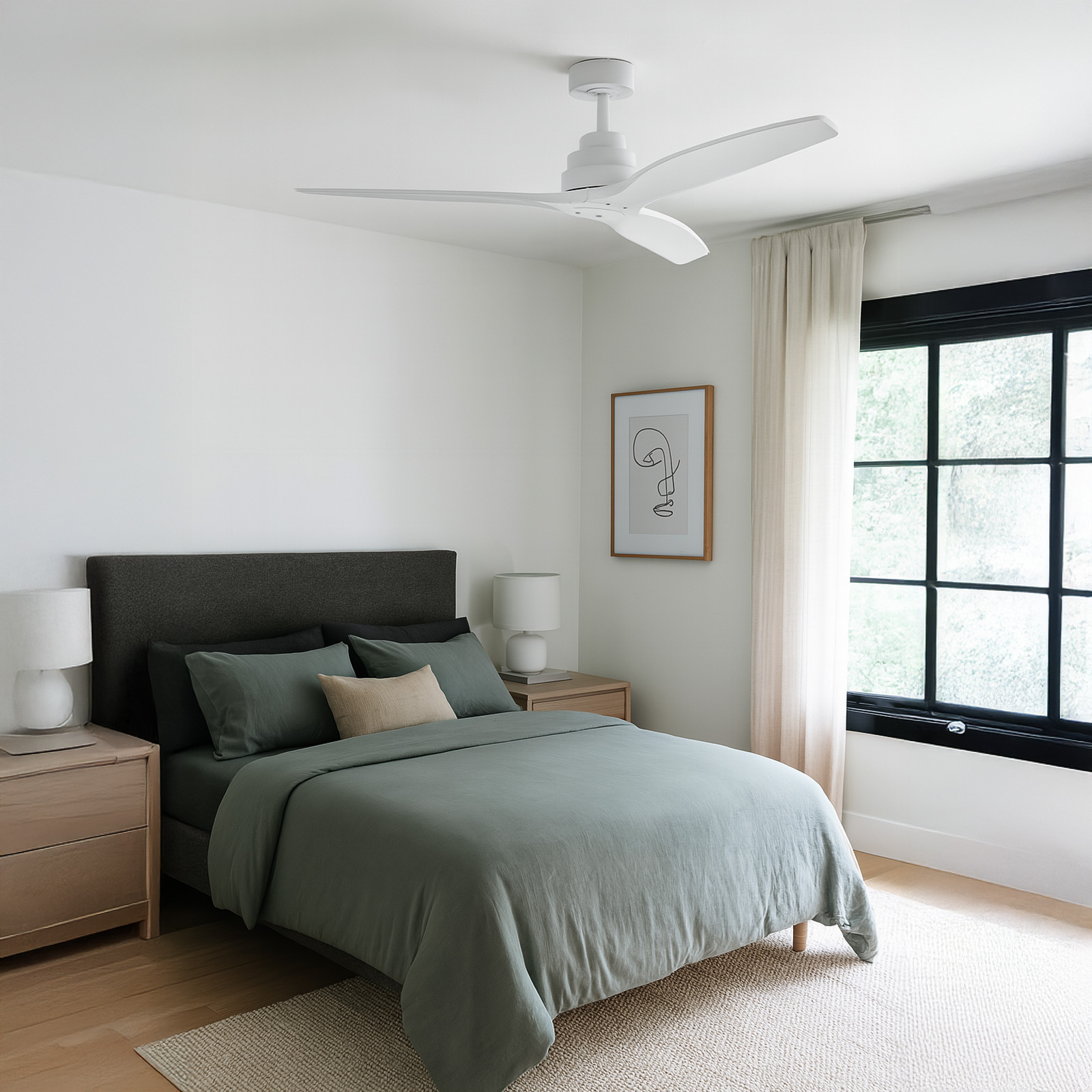 Dormitorio con cama, ropa de cama verde, ventilador de techo blanco, arte enmarcado, ventana con marco negro y suelo de madera.