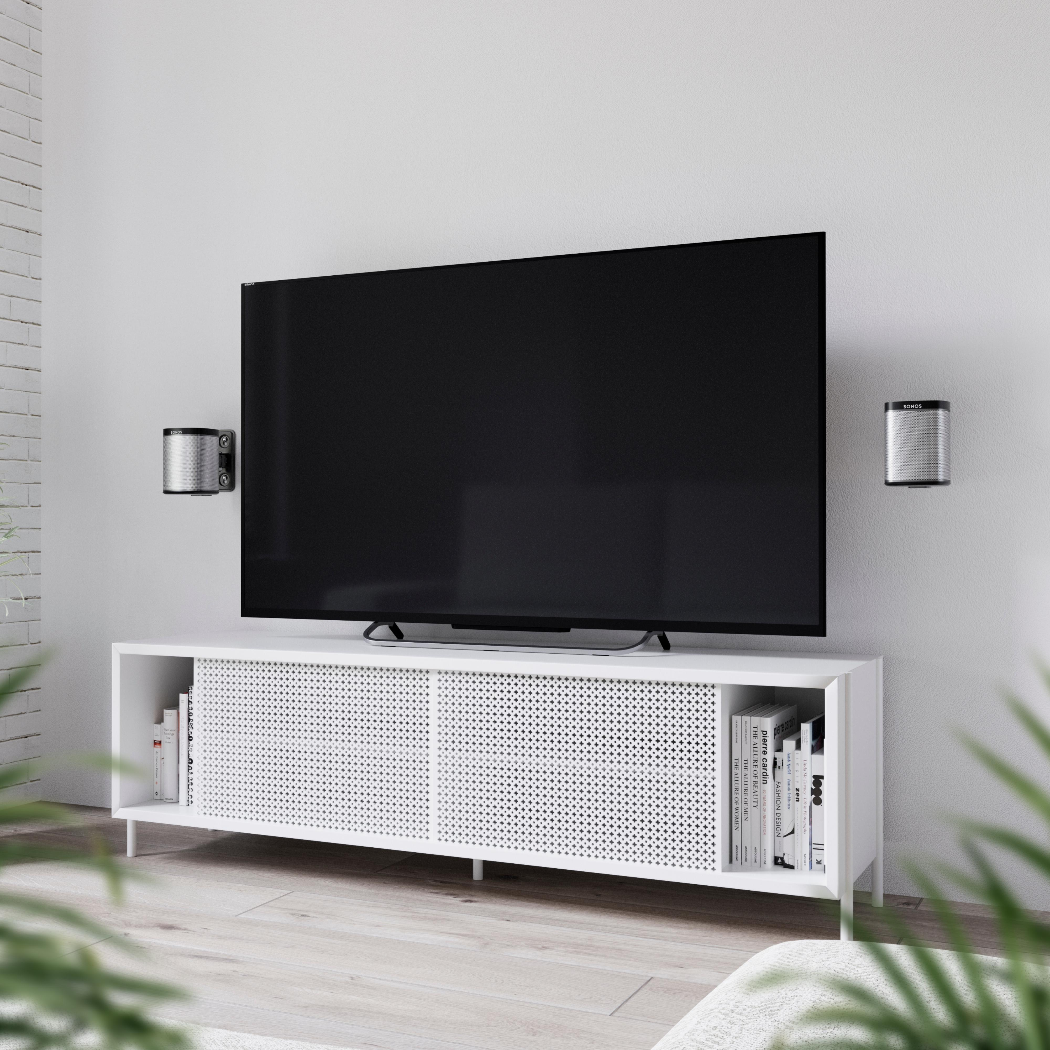 Modernes Wohnzimmer mit Fernseher, Lautsprechern und weißem Schrank. Lautsprecher sind an der Wand montiert.
