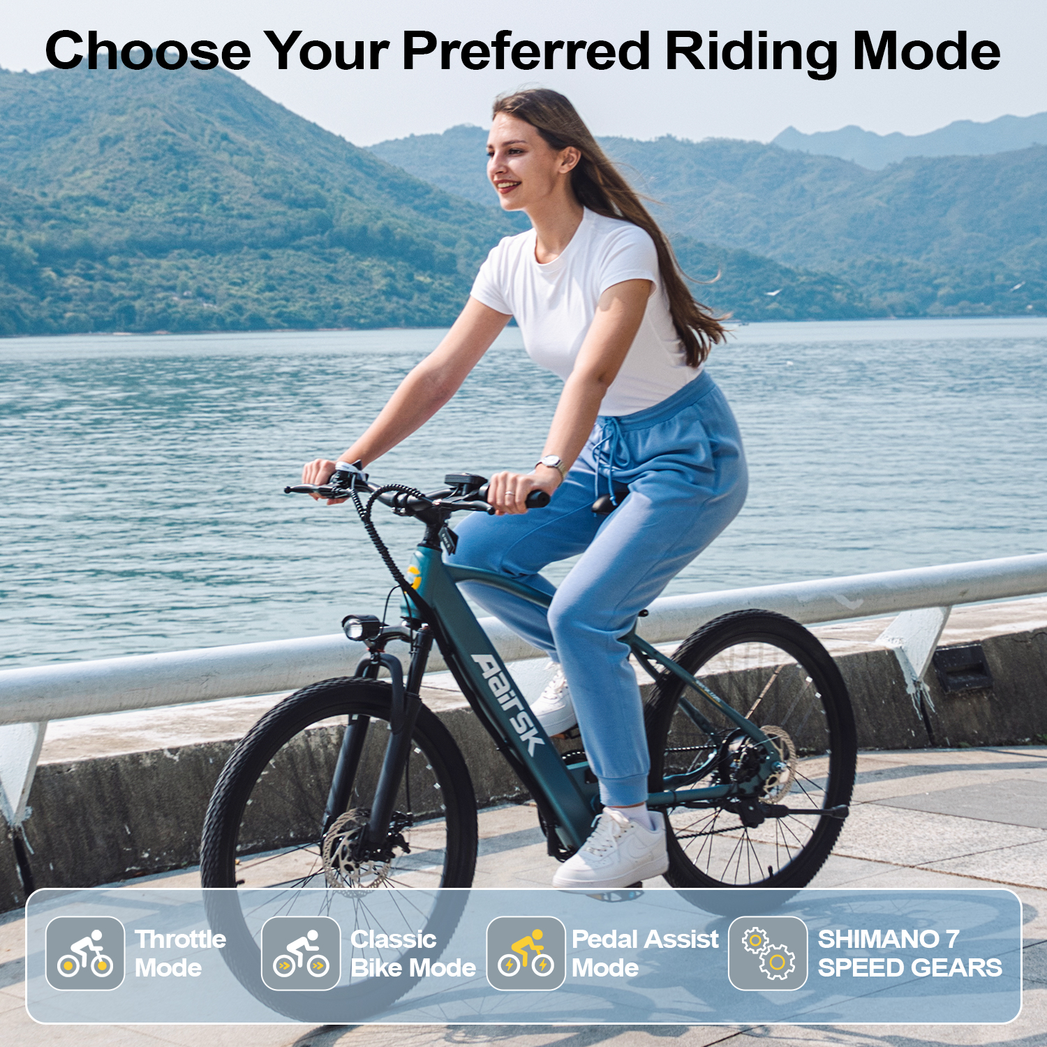 Eine Frau fährt ein grünes Elektrofahrrad. Sie trägt ein weißes Hemd und blaue Hosen. Der Hintergrund zeigt Wasser und Berge.