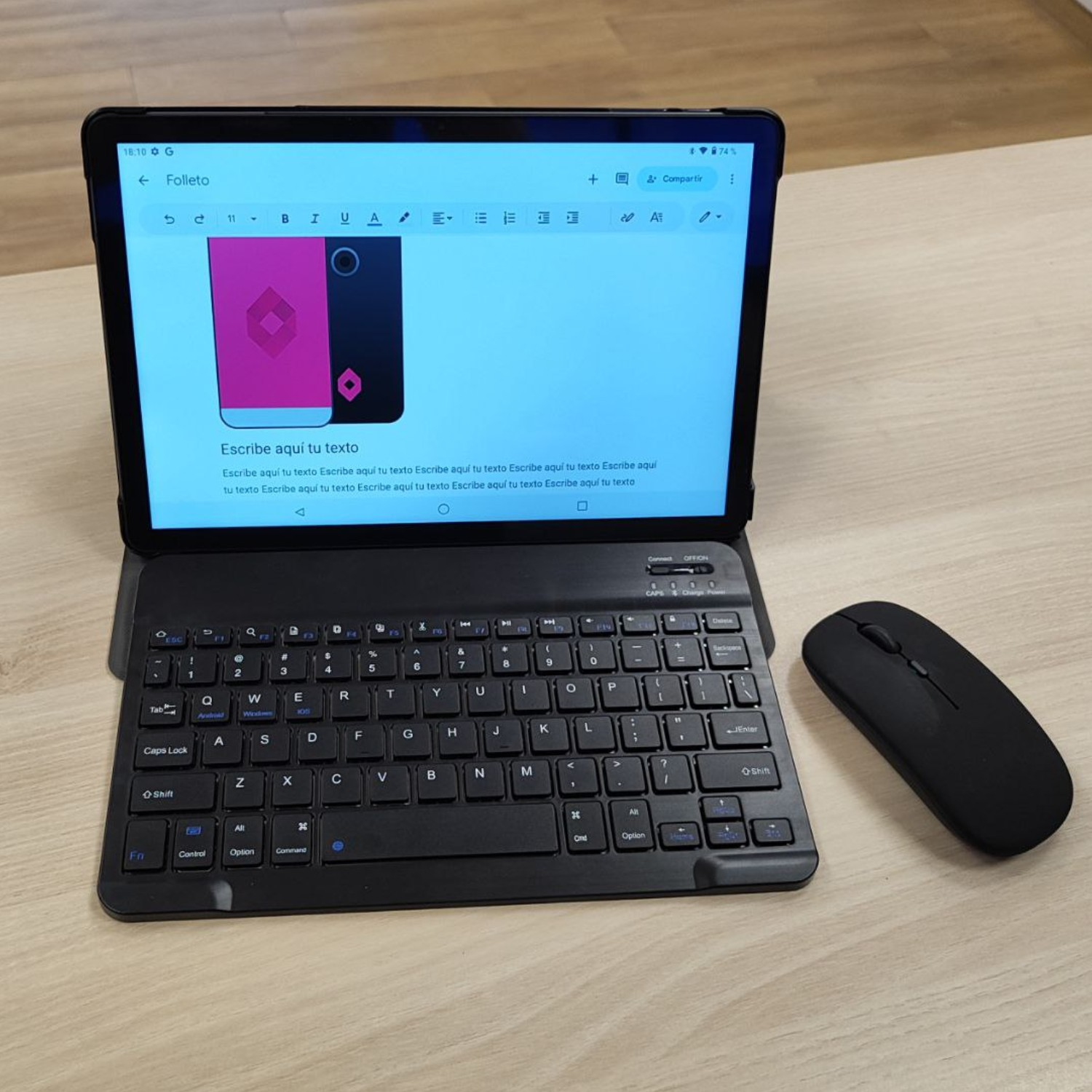 Tableta con teclado y ratón sobre una mesa de madera. La tableta muestra un documento con texto y un gráfico rosa.