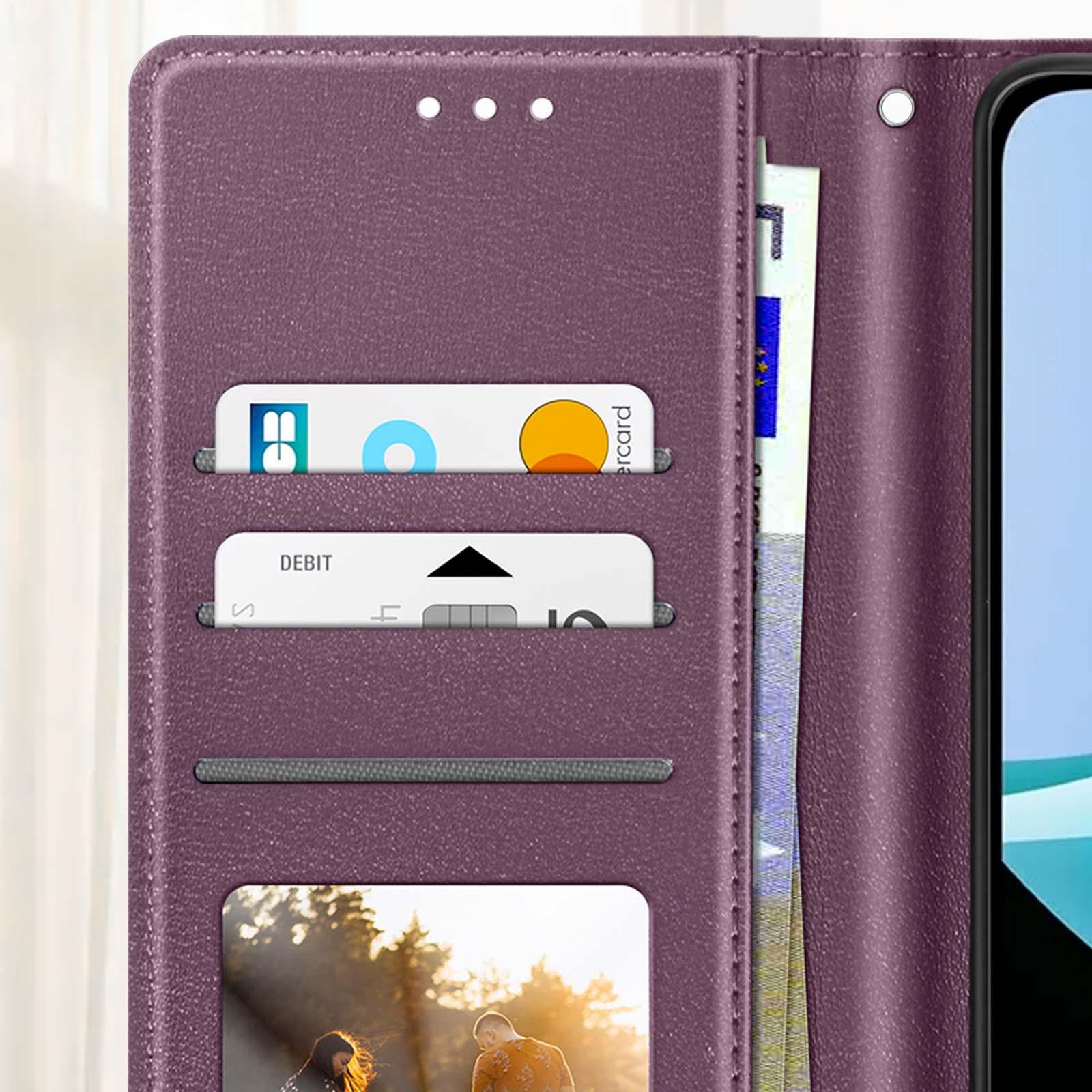 Primo piano di una custodia per telefono viola con carte di credito e contanti all'interno.