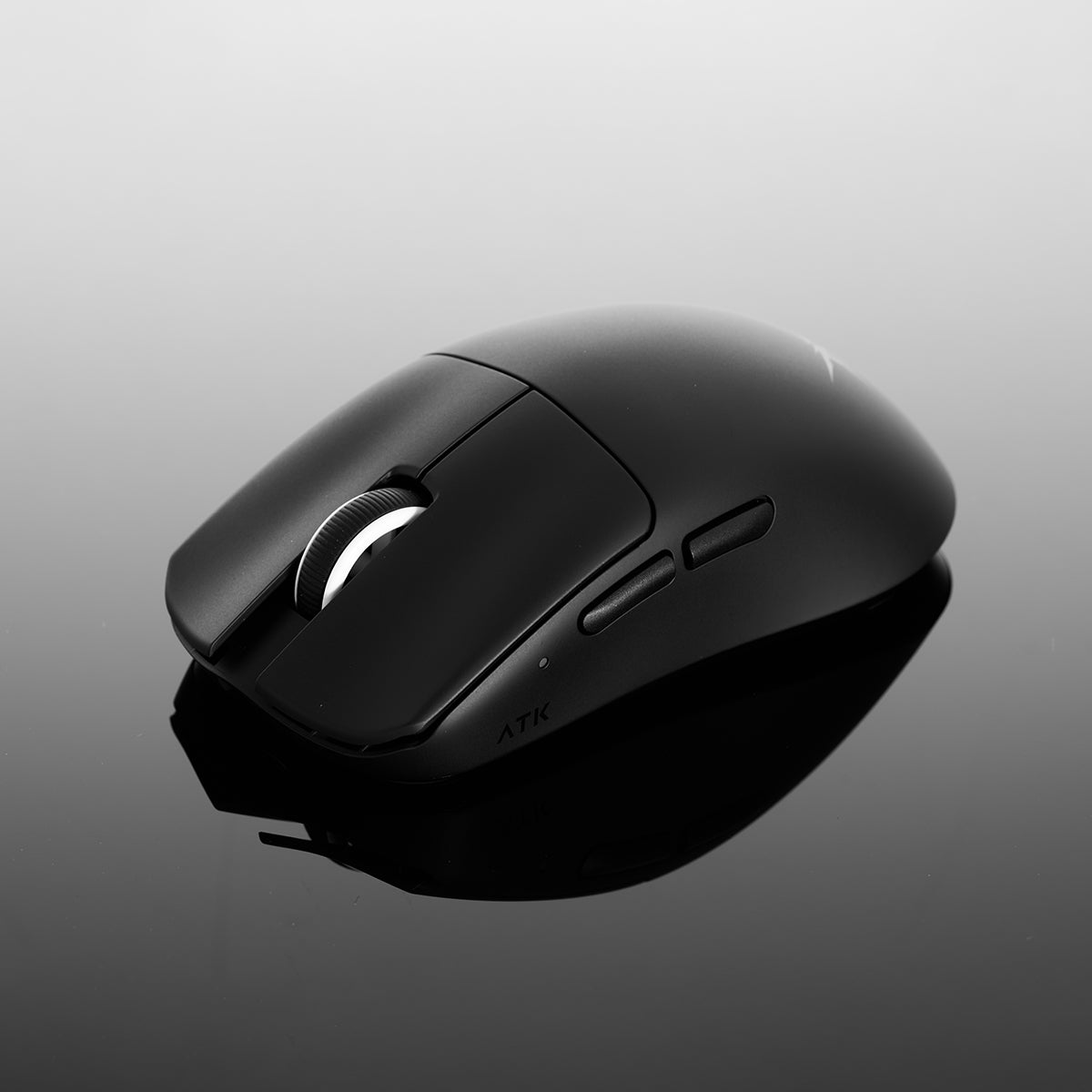 Un mouse nero con rotella e due pulsanti laterali su una superficie riflettente.