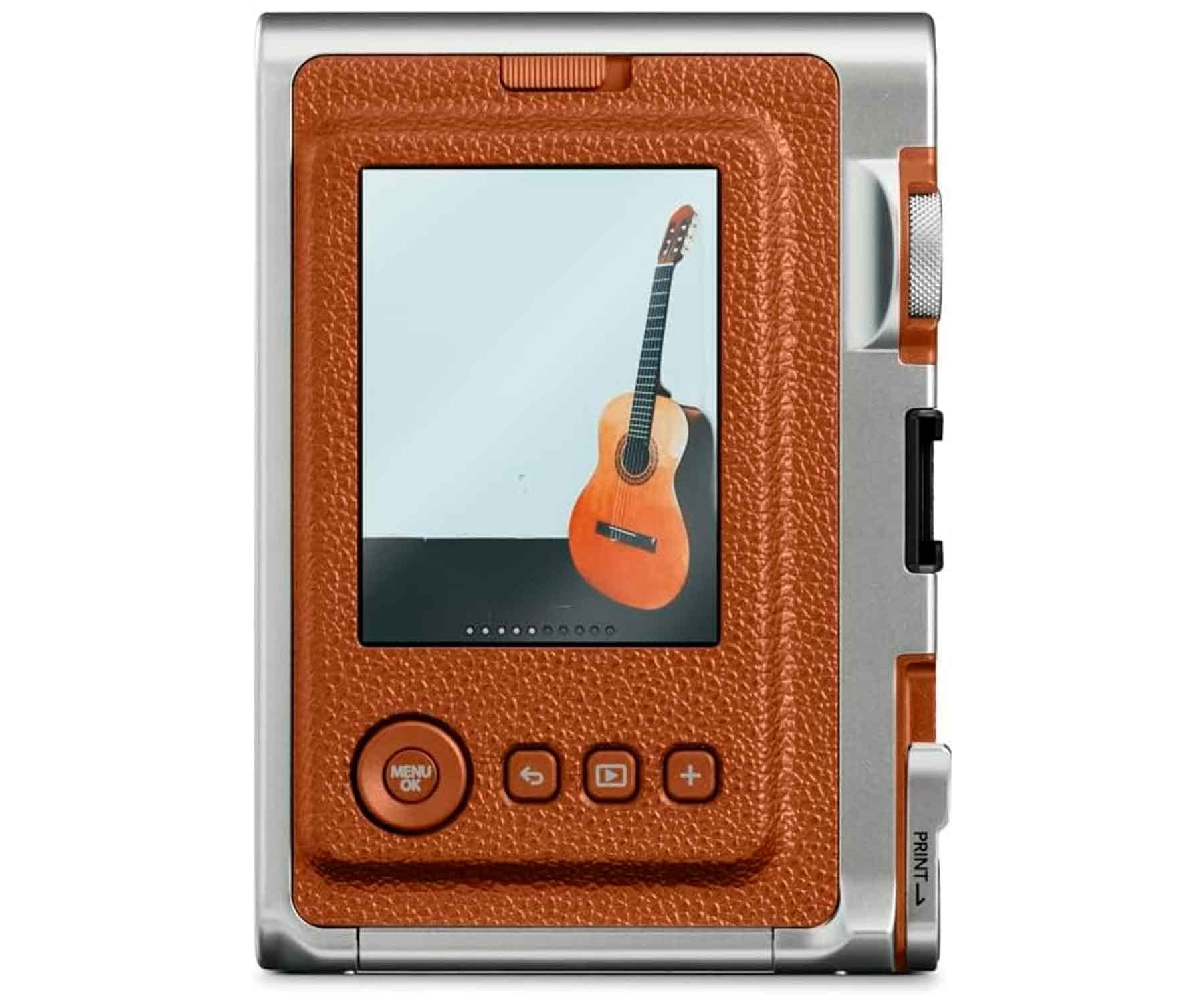 Eine Kamera mit orangefarbener lederartiger Rückseite, einem Bildschirm, der eine Gitarre zeigt, und silbernen Seiten. Knöpfe unten.