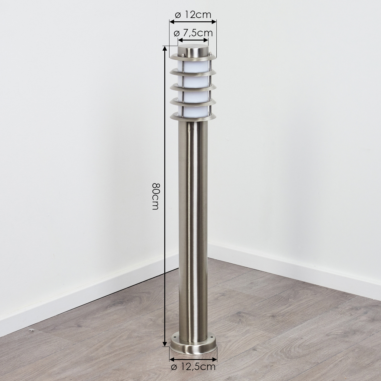 Eine Außenlampe aus Edelstahl. Sie hat einen runden Sockel und eine Oberseite mit einer Reihe horizontaler Ringe. Maße in cm.