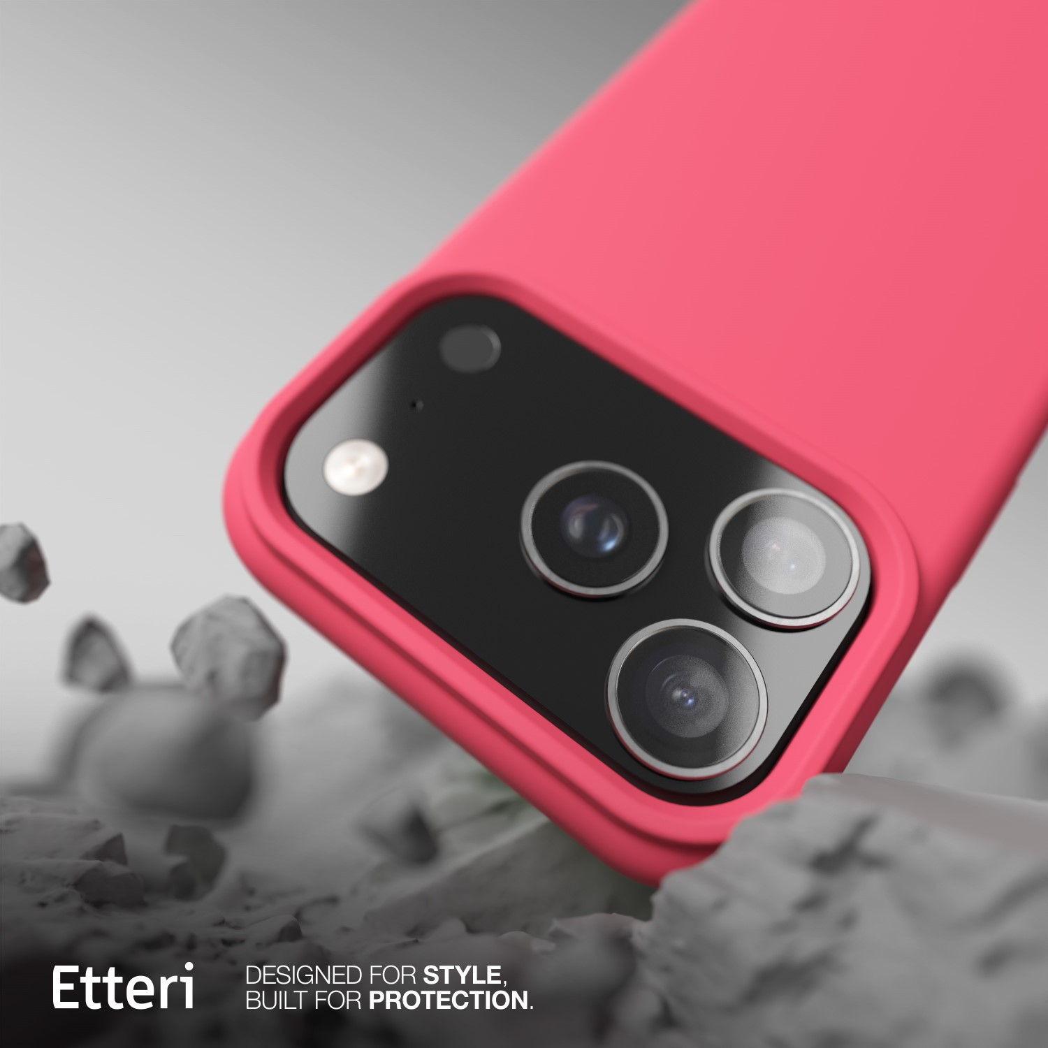 Różowe etui na telefon z aparatem z trzema obiektywami, z szarymi skałami na pierwszym planie i logo Etterri w lewym dolnym rogu.