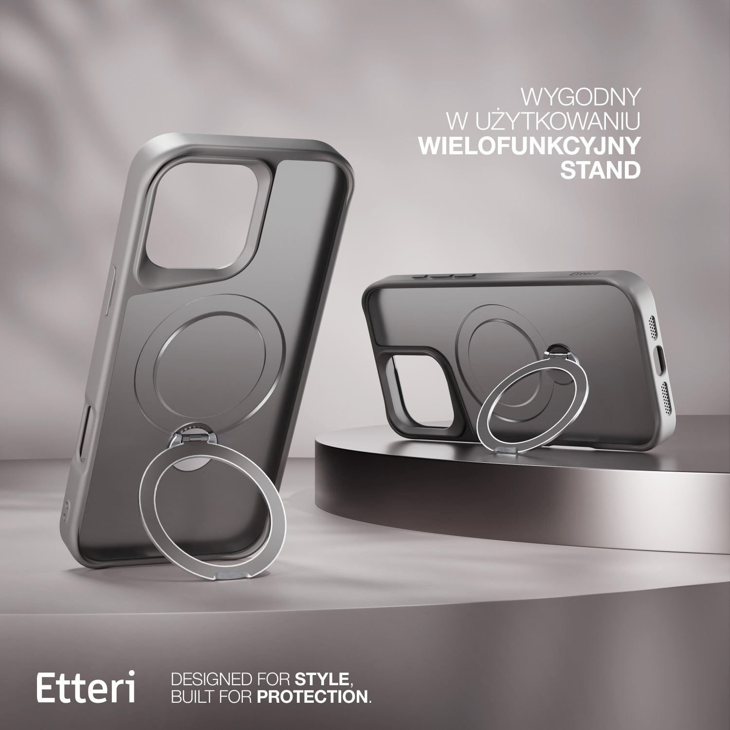 Due custodie grigie per telefono con anelli sono esposte su un piedistallo. Il testo recita 'Wygodny w użytkowaniu wielofunkcyjny stand'.