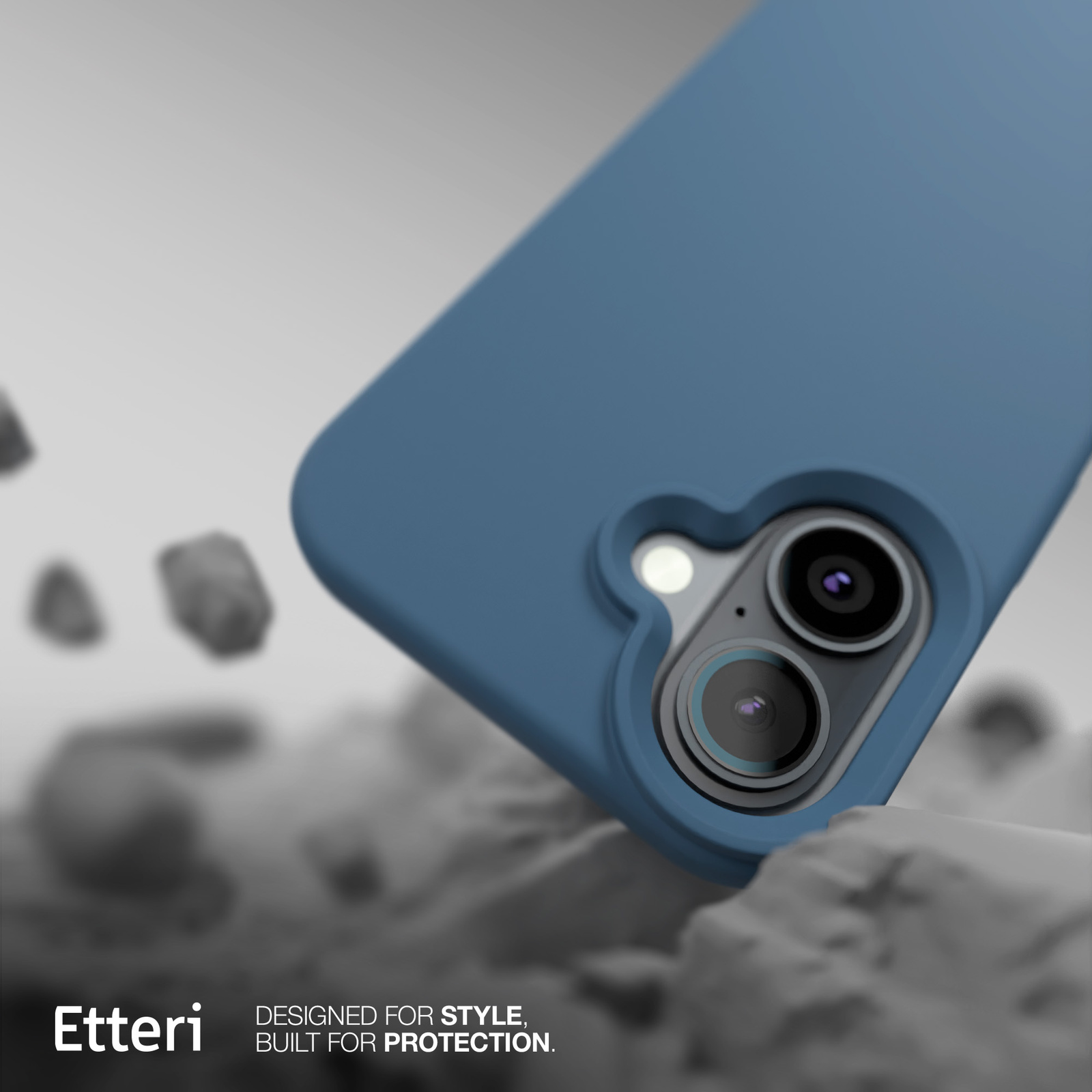 Custodia blu per telefono, che mostra l'obiettivo della fotocamera. Sfondo con rocce grigie e logo 'Etteri'.