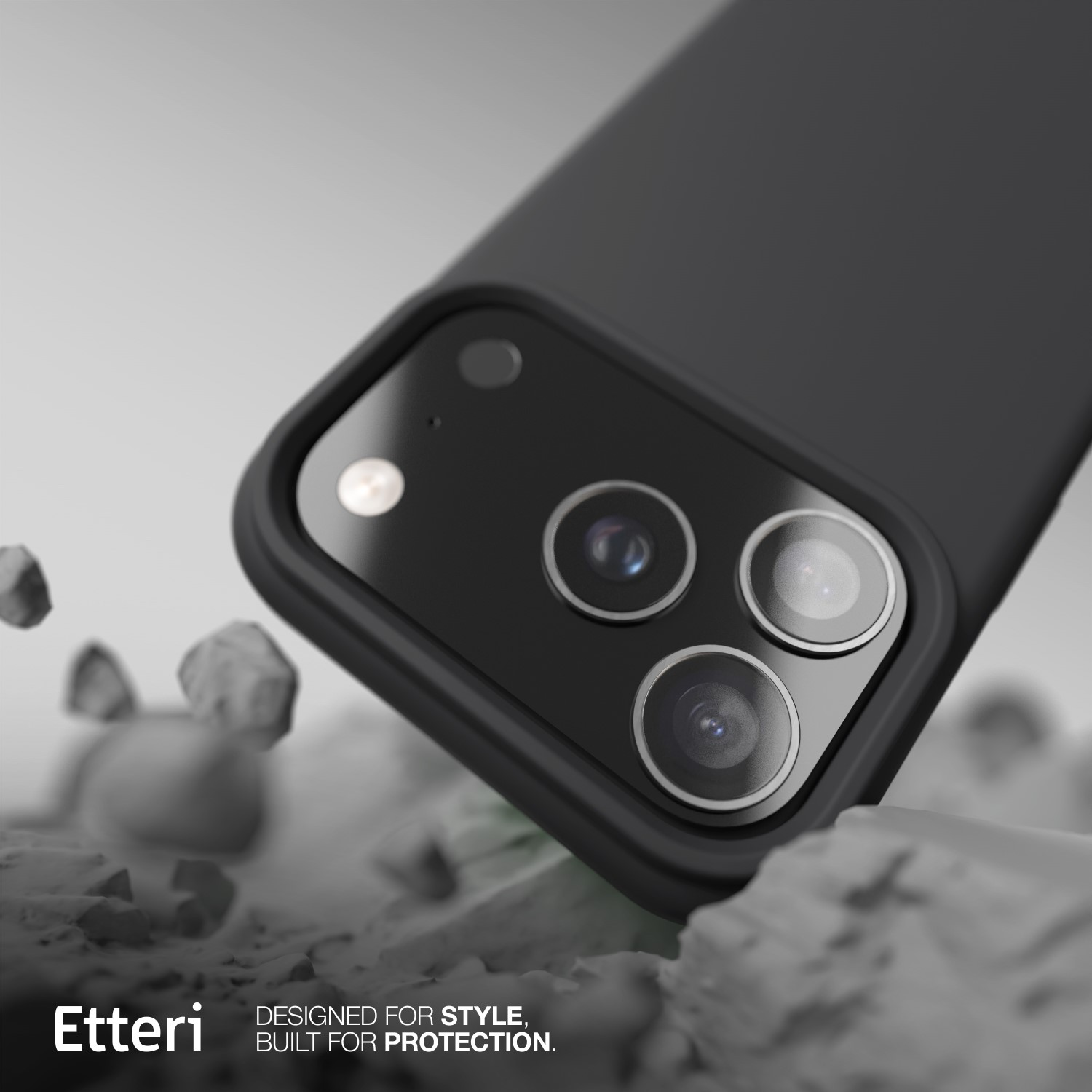 Zbliżenie czarnego etui na telefon z trzema obiektywami aparatu. Etui spoczywa na jasnej, teksturowanej powierzchni. Widoczne logo "Etteri".