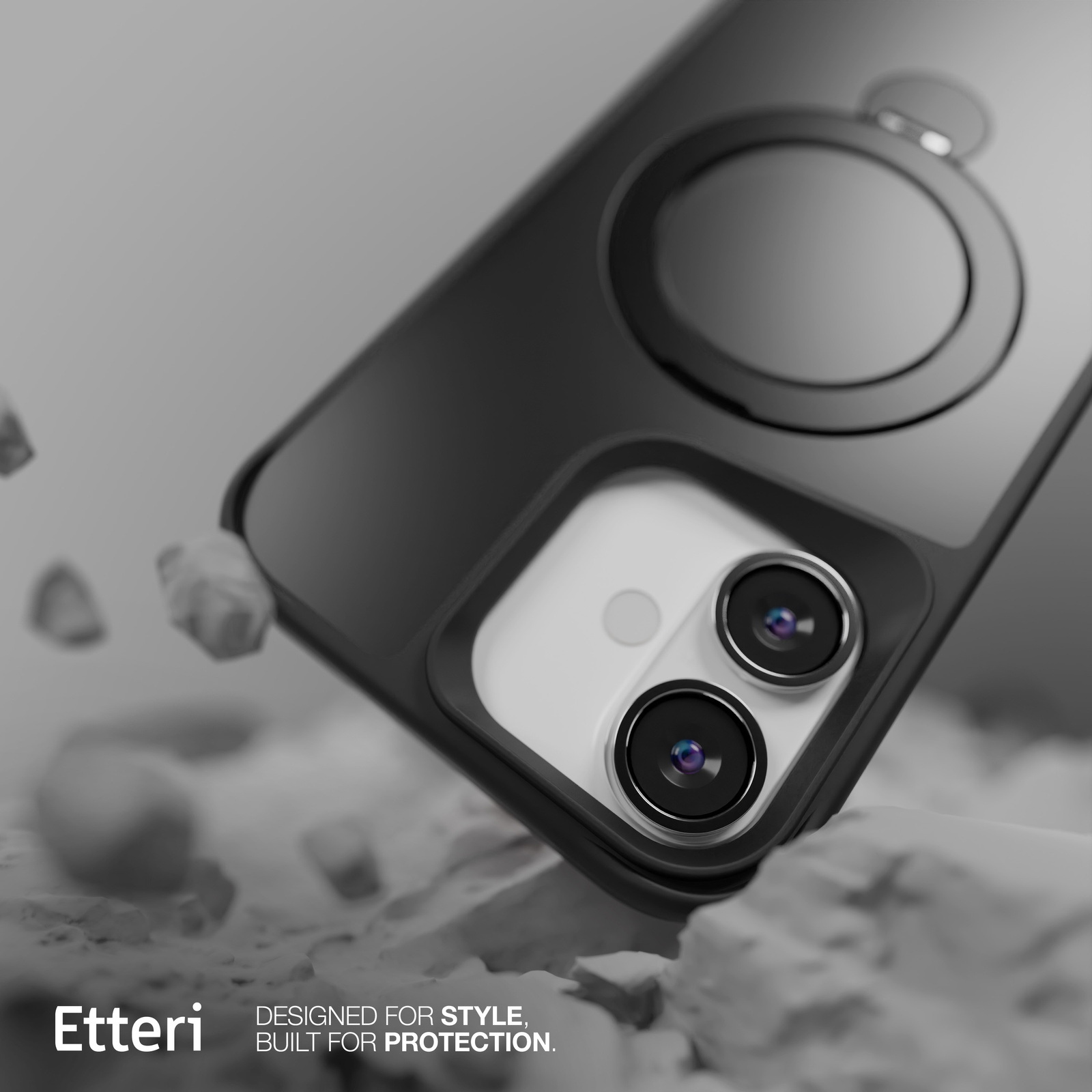 Custodia nera per telefono con anello. Due lenti visibili. La custodia poggia su una superficie di pietra. Logo "Etteri".