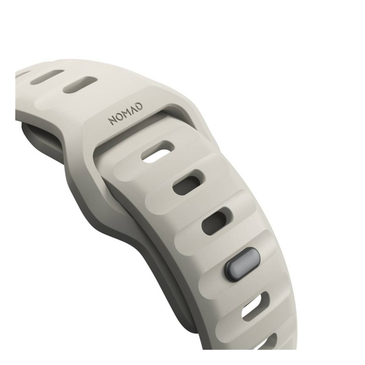 Primo piano di un cinturino grigio chiaro con la scritta 'NOMAD'. Il cinturino presenta diversi fori rettangolari e un piccolo bottone grigio.