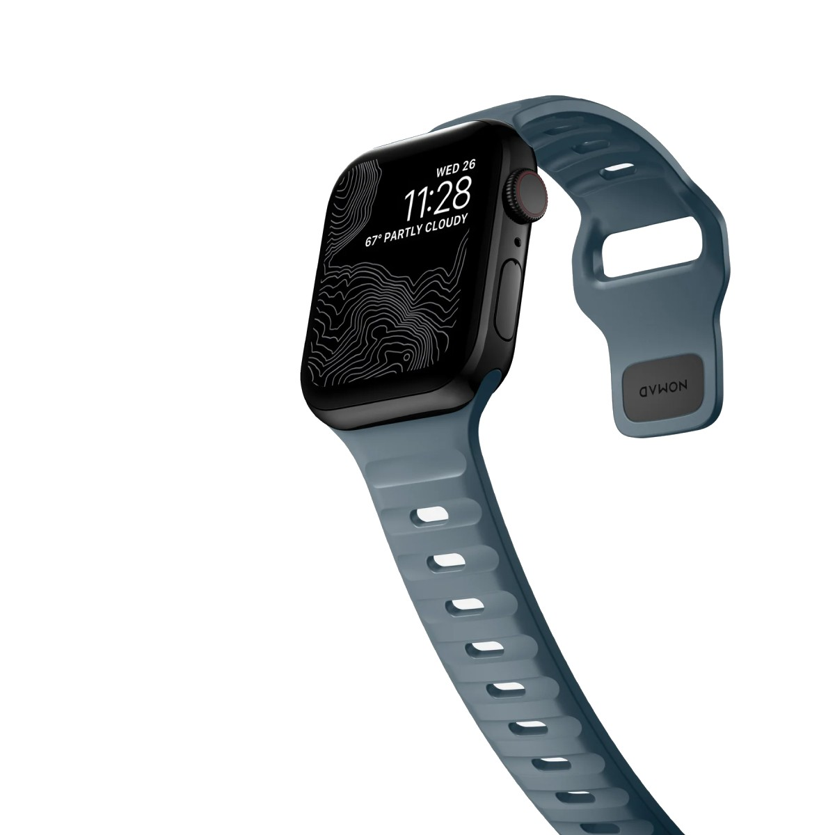 Un Apple Watch negro con una correa azul muestra la hora y el clima sobre un fondo blanco. La correa tiene la palabra NOMAD.
