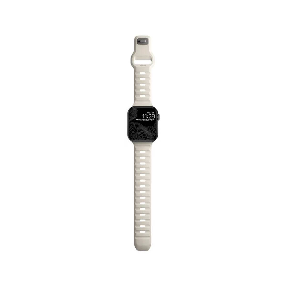 Un Apple Watch con correa color crema. La esfera muestra la hora, el clima y un diseño de mapa topográfico.