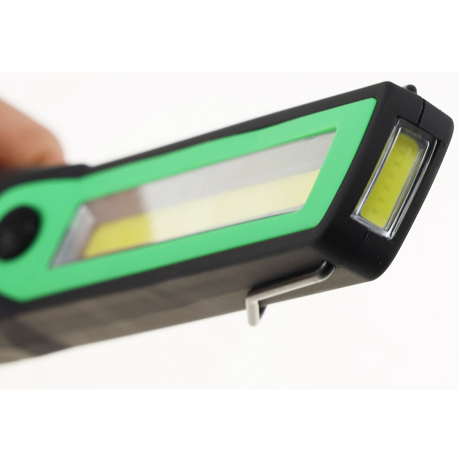 Nahaufnahme einer schwarzen und grünen LED-Arbeitsleuchte. Das Licht wird in der Hand gehalten, mit weißem Hintergrund.