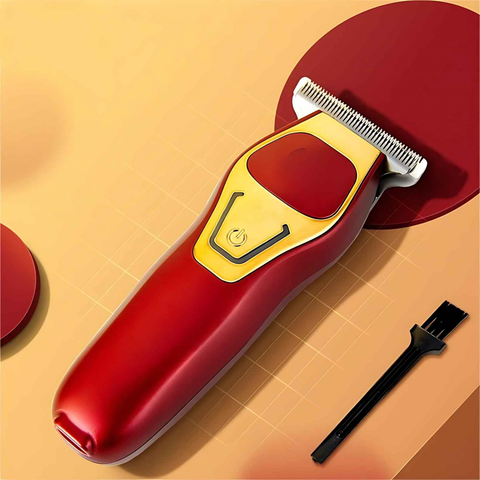Ein roter und goldener elektrischer Haarschneider mit einer schwarzen Reinigungsbürste auf gelbem und rotem Hintergrund.