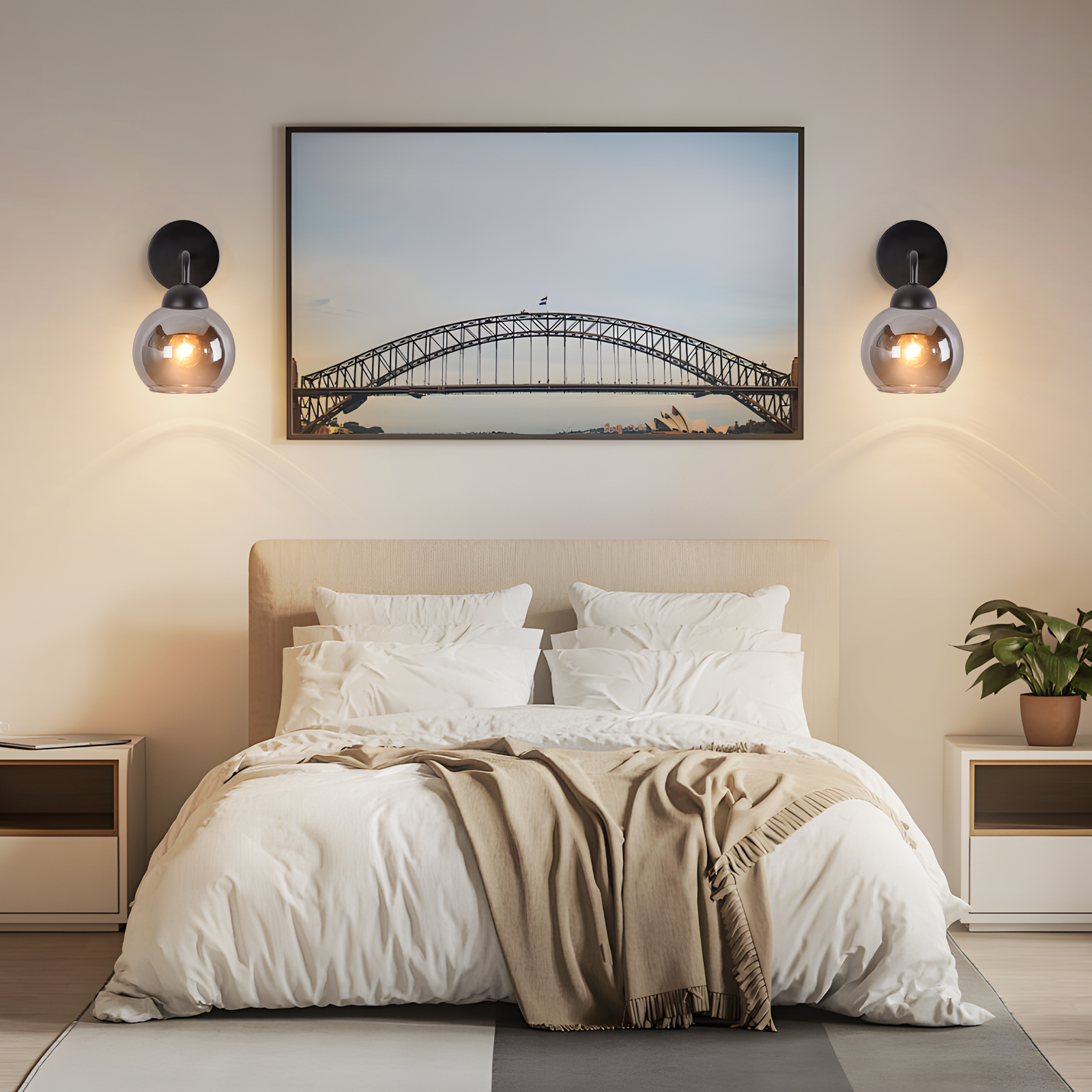 Escena de dormitorio con cama, imagen del puente de la bahía de Sídney, lámparas, mesitas y planta.