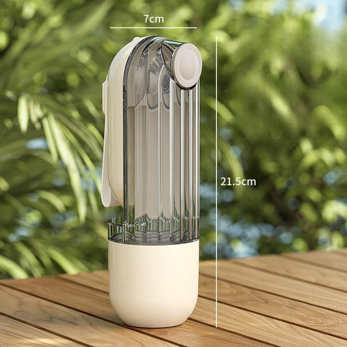 Eine cremefarbene und transparente Wasserflasche steht auf einem Holztisch. Der Hintergrund ist ein verschwommenes grünes Laub.