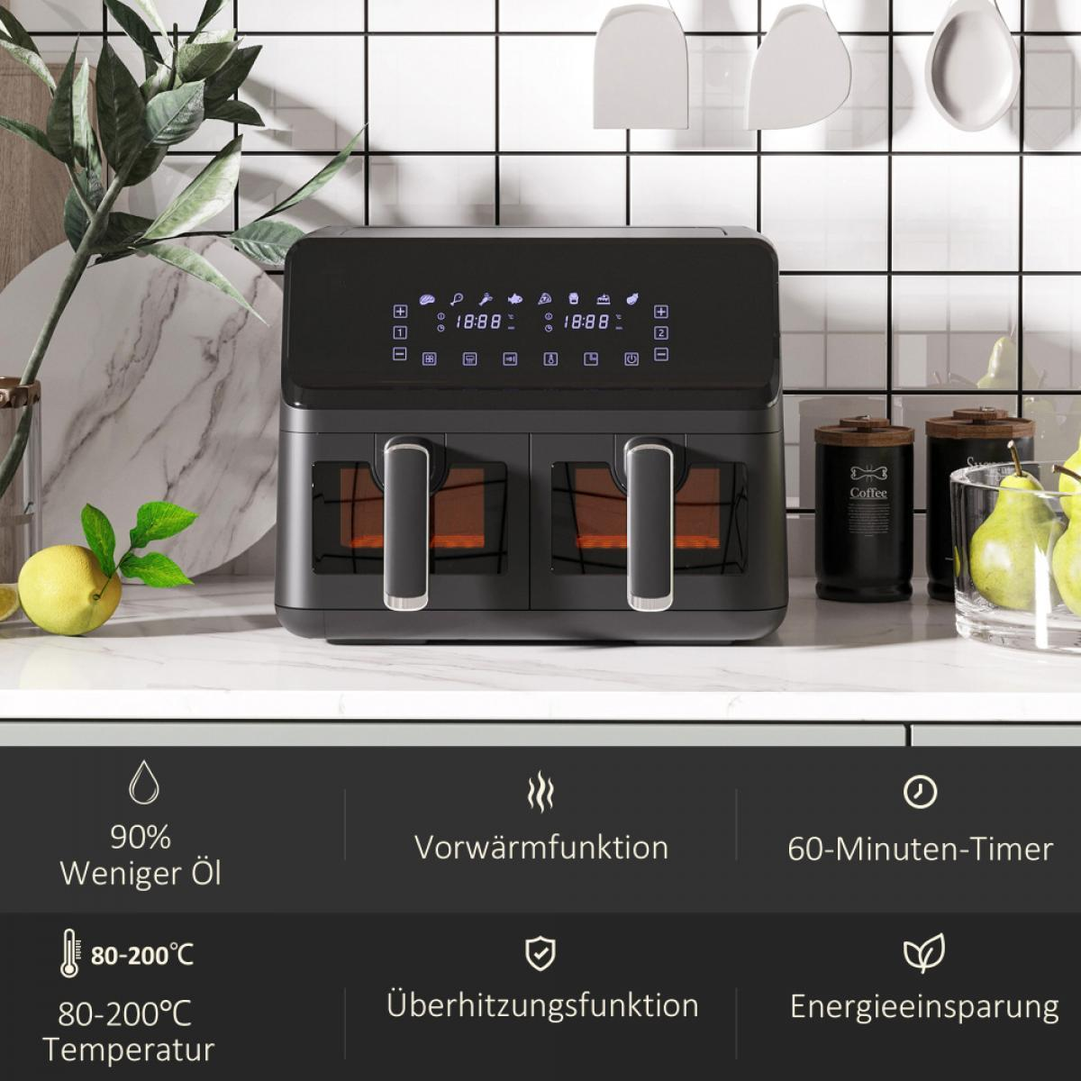 Ein schwarzer Airfryer mit Digitalanzeigen steht auf einer weißen Arbeitsplatte. Er hat Griffe und transparente Fächer. Gläser und Früchte sind im Hintergrund.