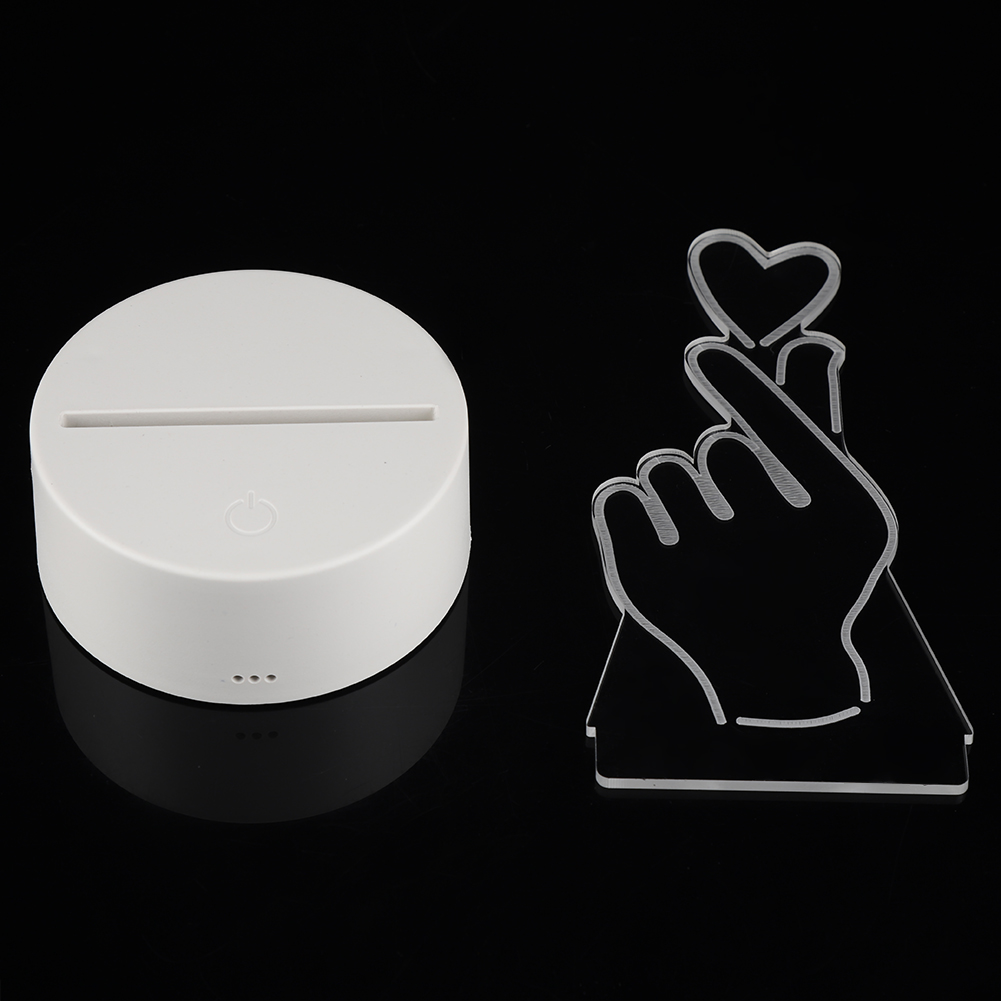 Weißer LED-Sockel und herzförmiges Acryl-Hand-Symbol auf schwarzem Hintergrund. Die Hand formt ein Herz.