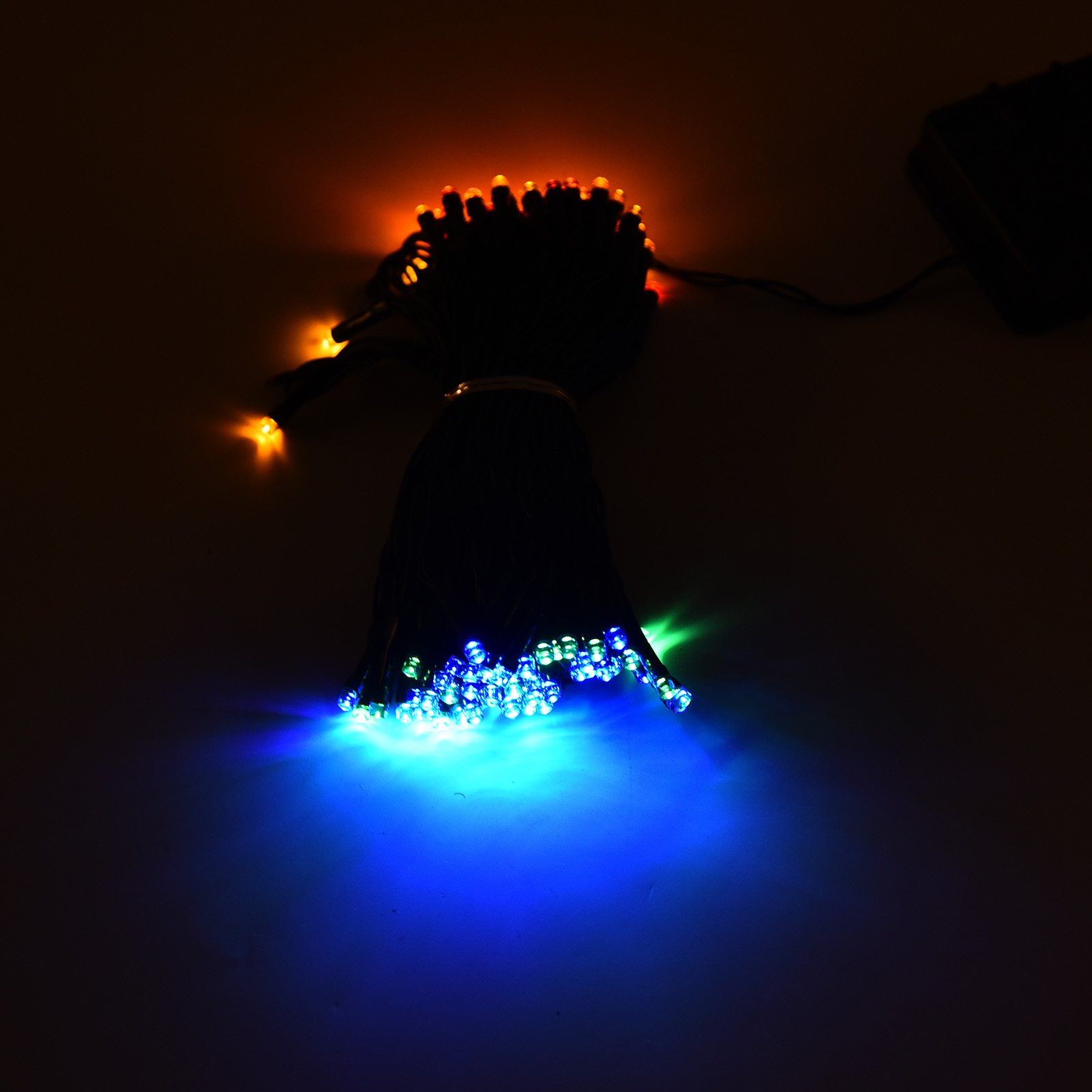 Lichterketten mit blauen, grünen und orangefarbenen LEDs. Die Lichter sind eingeschaltet, mit dunklem Hintergrund.