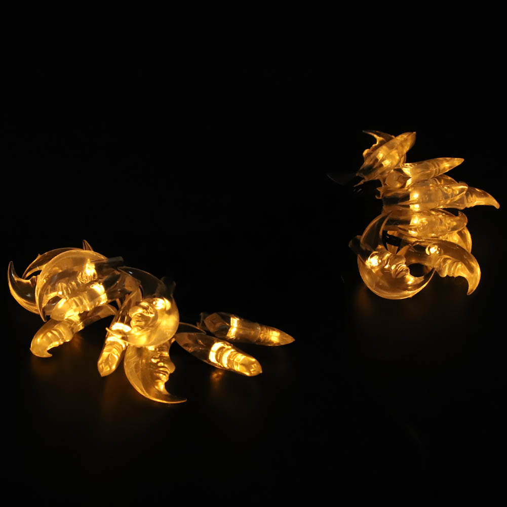 Zwei Glasskulpturen von Fabelwesen mit gelben Innenlichtern. Eines ähnelt einer Krabbe, das andere einem Skorpion, auf schwarzem Hintergrund.