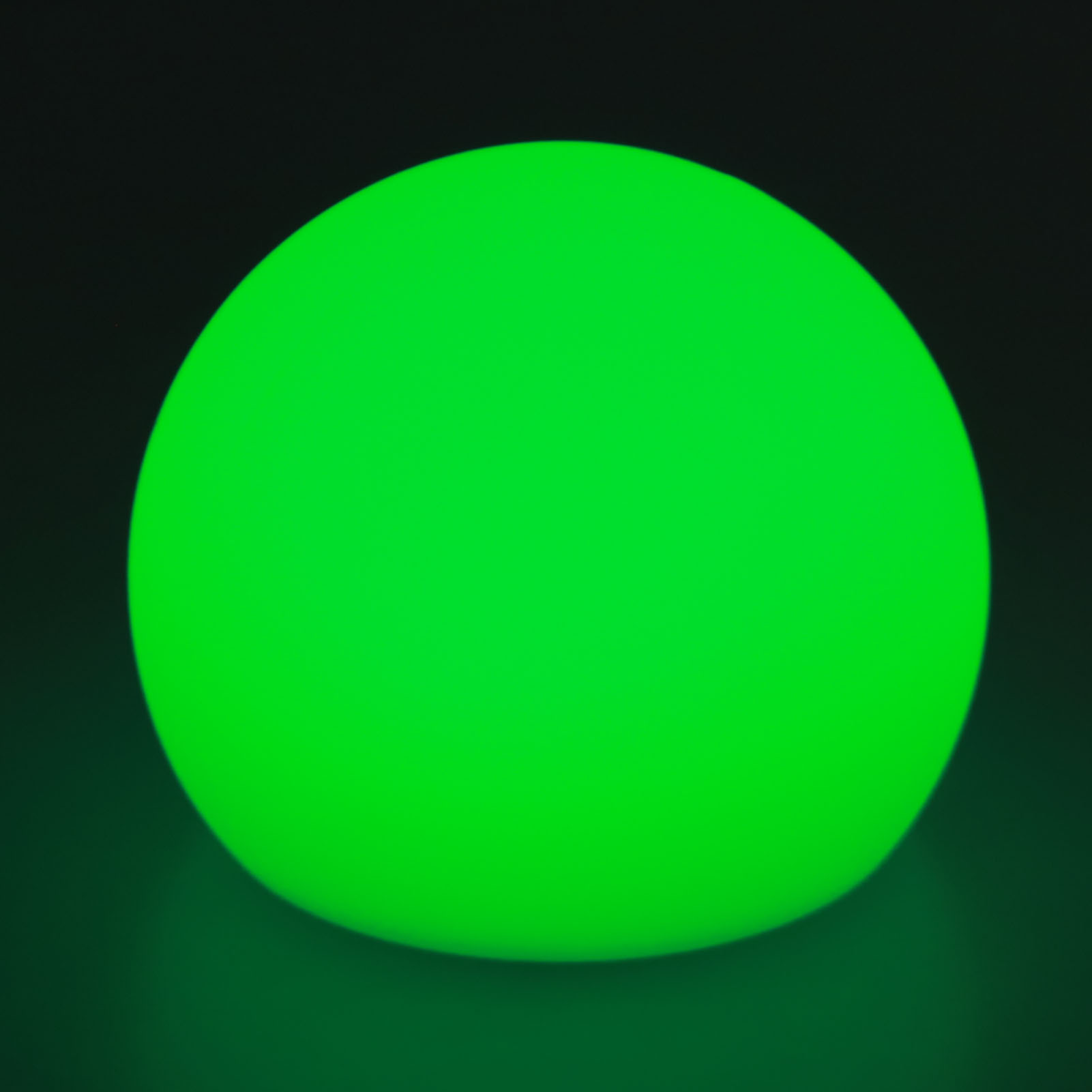 Eine leuchtende grüne Kugel vor dunklem Hintergrund. Die Kugel ist das Hauptaugenmerk und strahlt sanftes Licht aus.