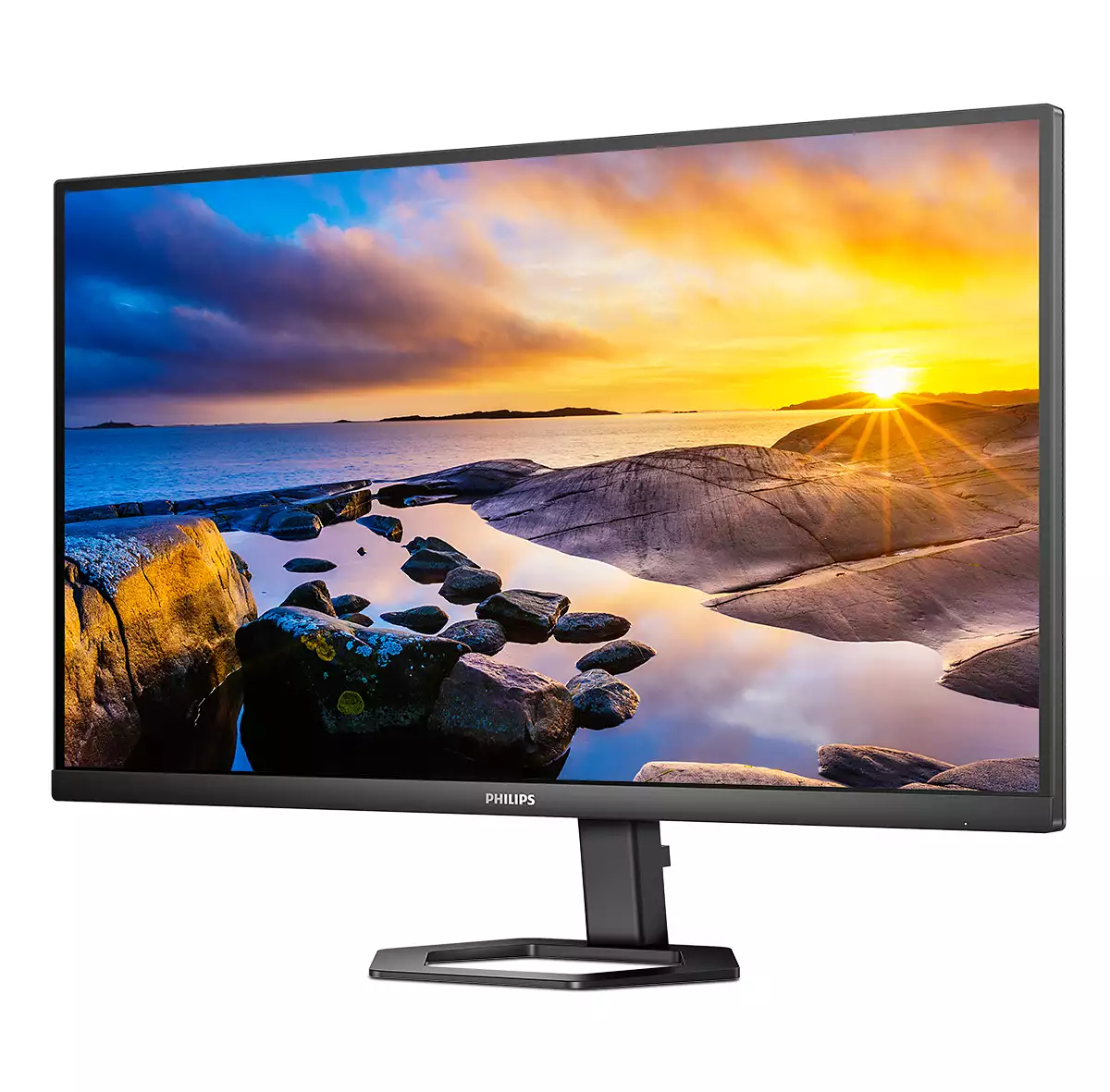 Un monitor Philips mostra un tramonto panoramico su acqua e rocce. Il monitor è nero, con supporto nero e sfondo bianco.