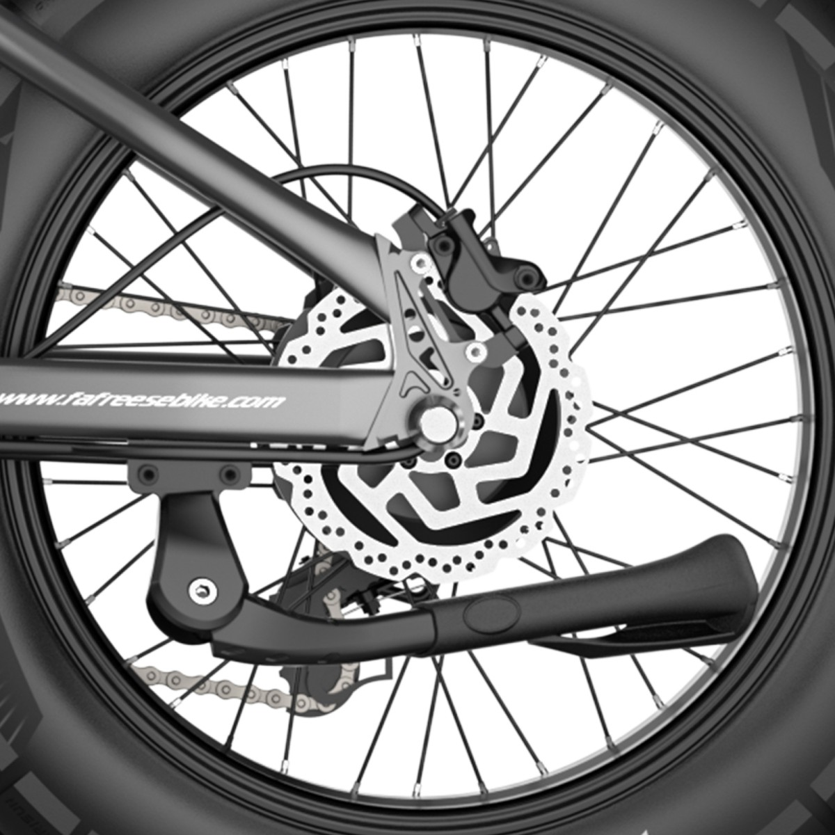 Zbliżenie koła i ramy roweru. Koło ma szprychy i hamulec tarczowy. Podpórka jest przymocowana do ramy.