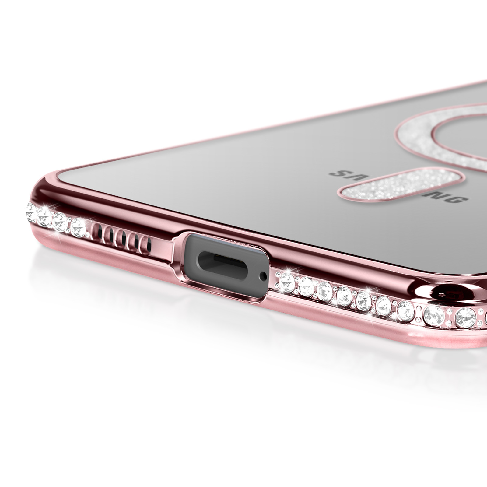 Gros plan d'une coque de téléphone or rose avec cristaux incrustés et dos transparent, avec le mot Samsung.