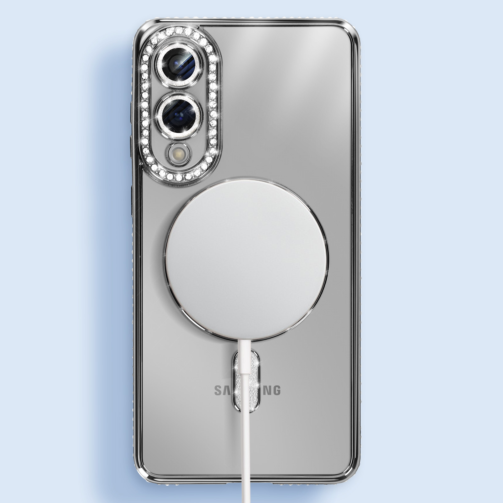 Coque de téléphone transparente avec anneau de caméra serti de diamants, MagSafe blanc et câble de charge, sur fond bleu clair.