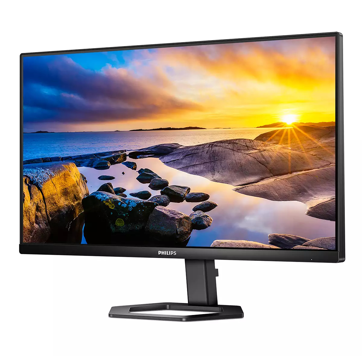 Un monitor per computer Philips mostra un tramonto su una costa rocciosa. Il monitor è nero, con un supporto nero. La scena si riflette.