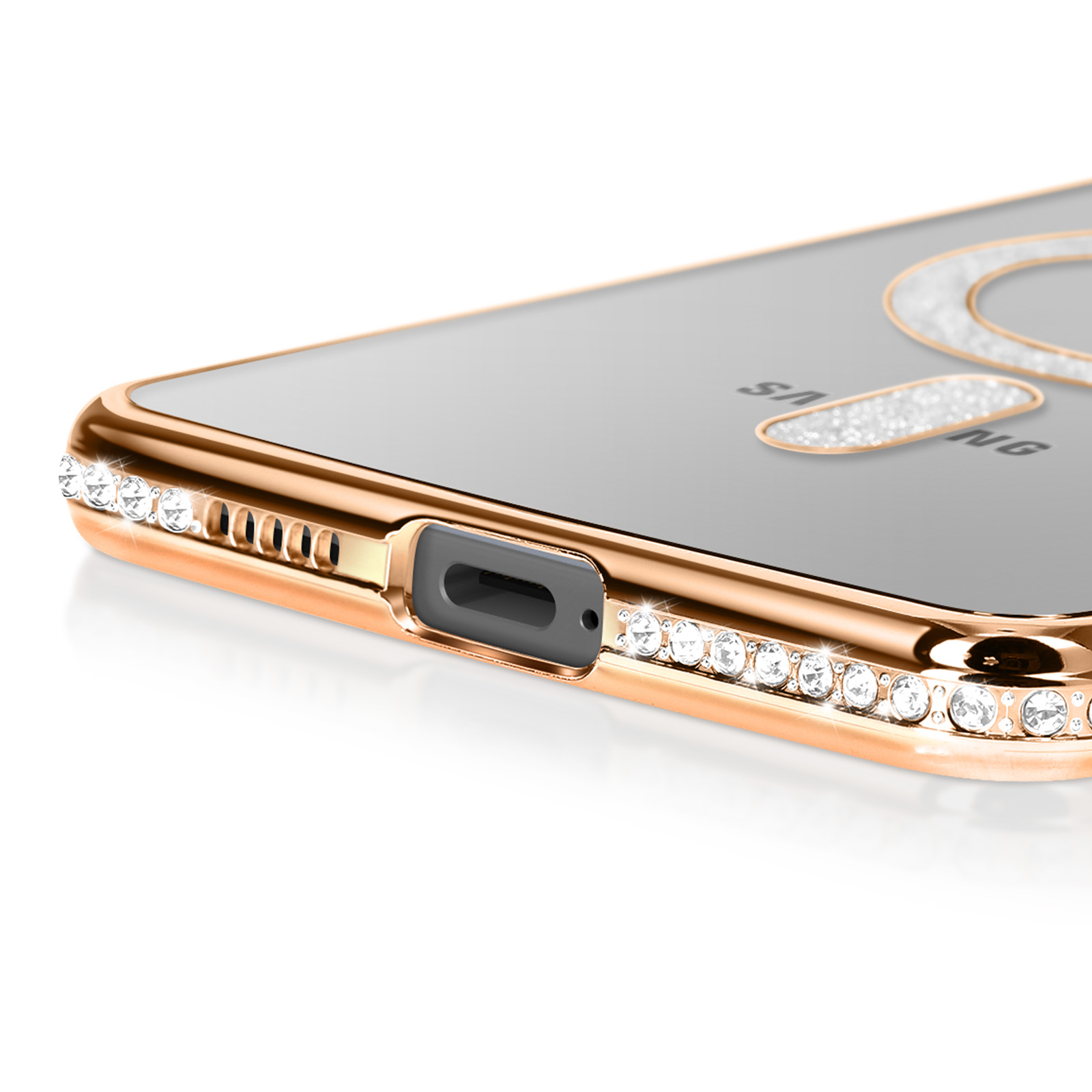 Gros plan sur une coque de téléphone dorée avec des strass transparents. L'écran affiche le logo Samsung.